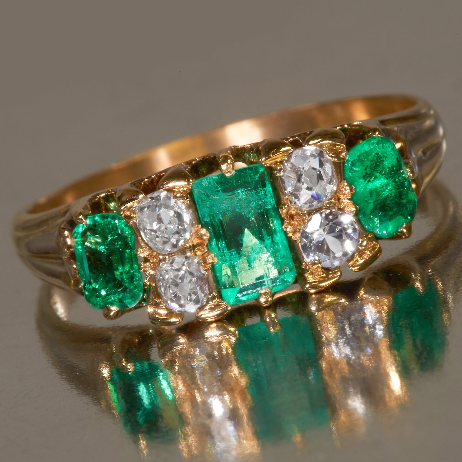 EMERALD AND DIAMOND RING: EMERALD AND DIAMOND RING,High carat gold.Gemstones totalling approx. 0.84 ct.Vibrant well matched emeralds.Diamonds bright and lively.Size N 1/2.3.2 grams.