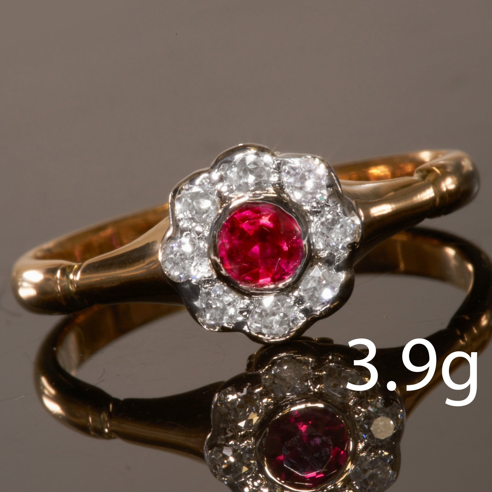 RUBY AND DIAMOND CLUSTER RING: RUBY AND DIAMOND CLUSTER RINGhigh carat gold.Vibrant rubyDiamonds bright and lively, totalling approx. 0.32 ct.Size R.3.9 grams.Lovely ring, good condition.