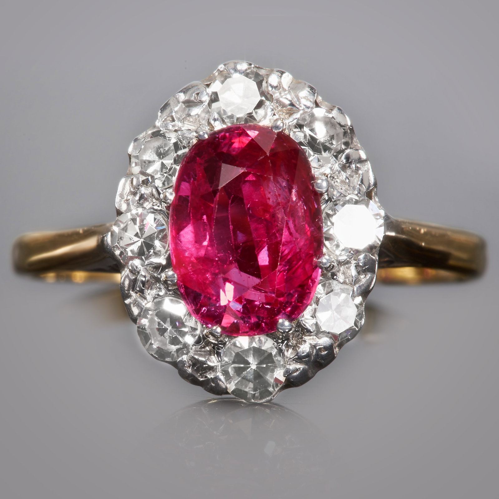 RUBY AND DIAMOND CLUSTER RING: RUBY AND DIAMOND CLUSTER RING. high carat goldlarge vibrant ruby with great clarity, approx. 1.72 ct.Bright and lively diamonds.size N2.6 grams