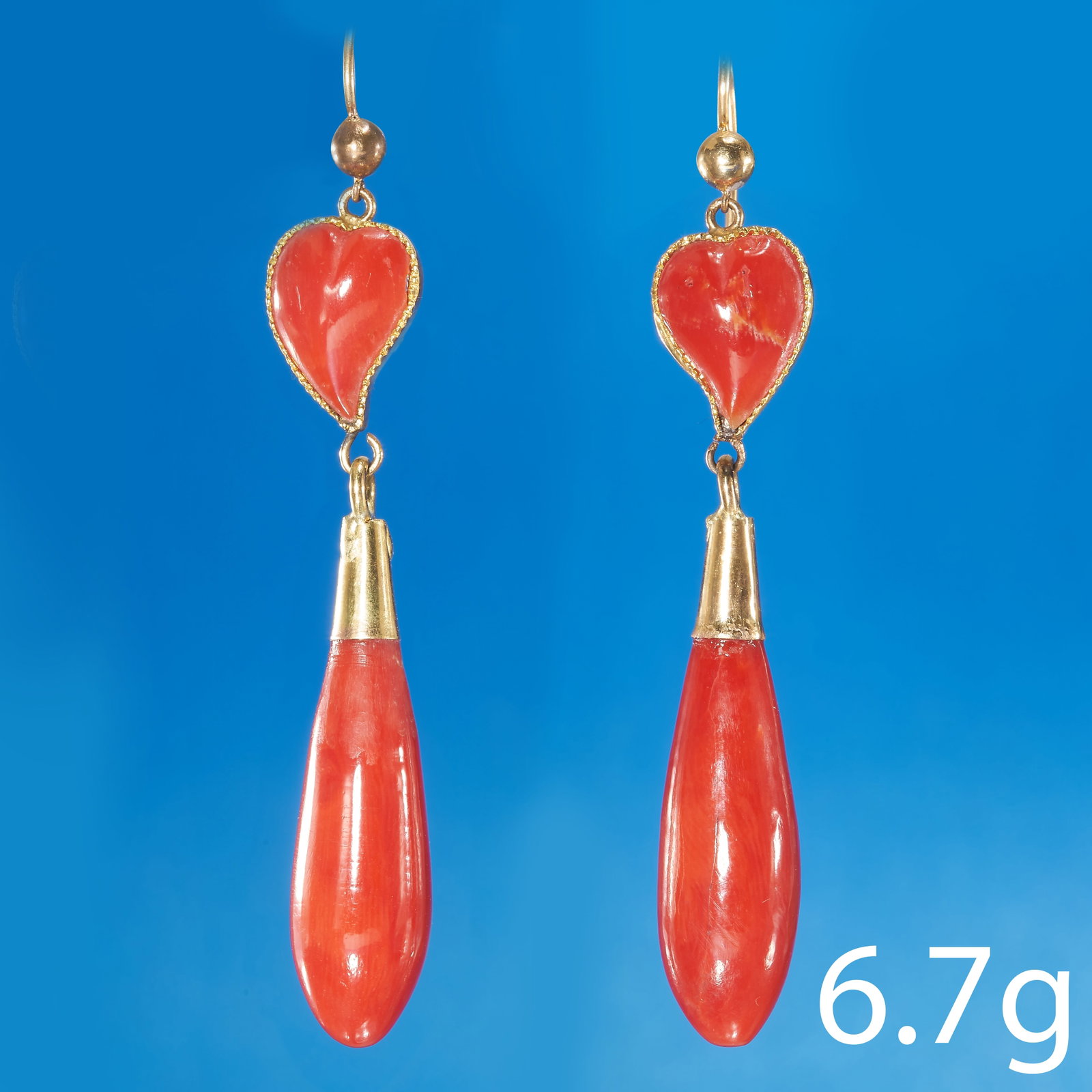 PAIR OF CORAL EARRINGS: PAIR OF CORAL EARRINGS,High carat gold.The top in the shape of a heart.Elongated drops.L. 5.9 cm.6.7 grams.