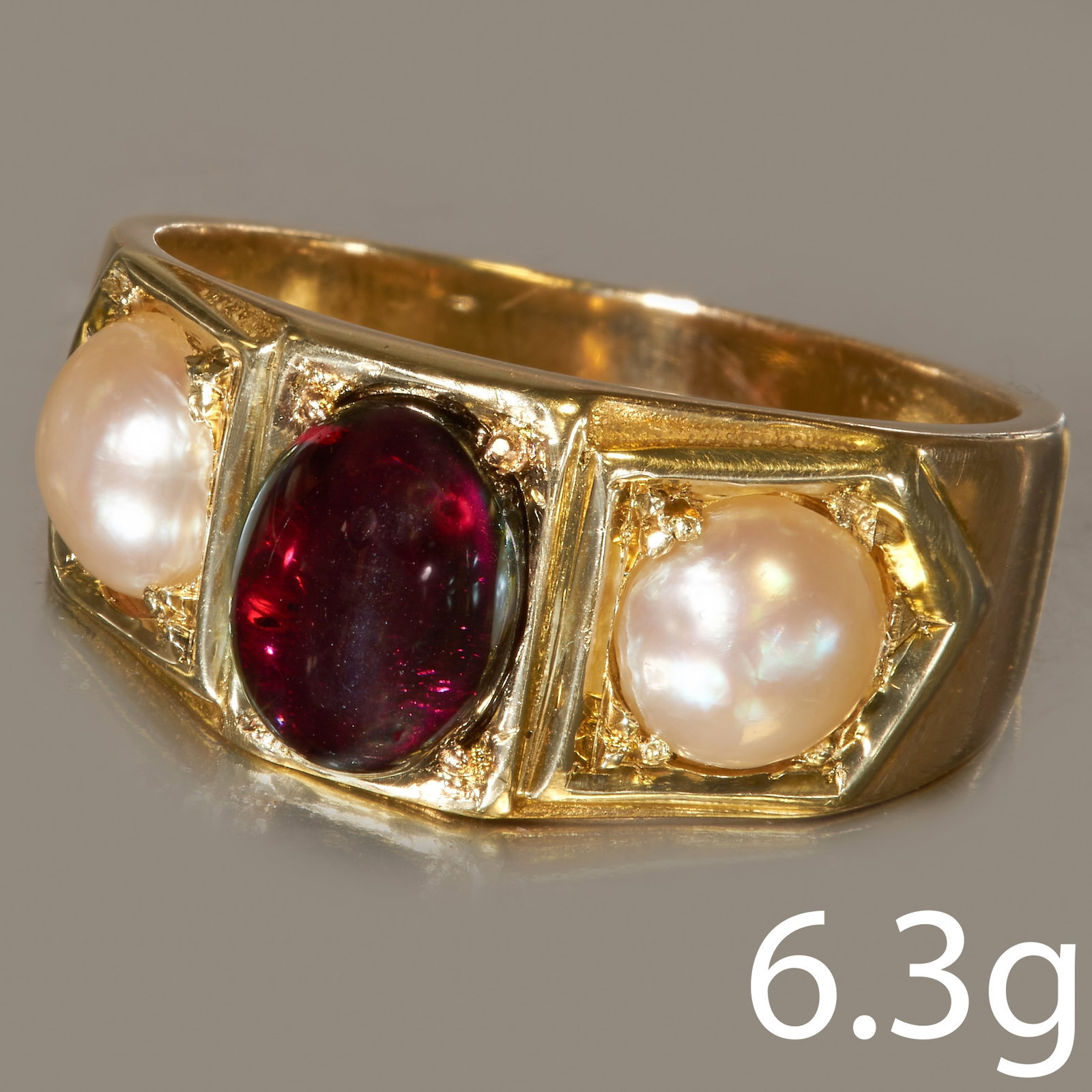GARNET AND PEARL 3-STONE RING: GARNET AND PEARL 3-STONE RING,in high carat gold.Vibrant cabochon cut garnet.A pearl on each side (Untested).Size M 1/2.6.3 grams.Lovely ring, good condition.