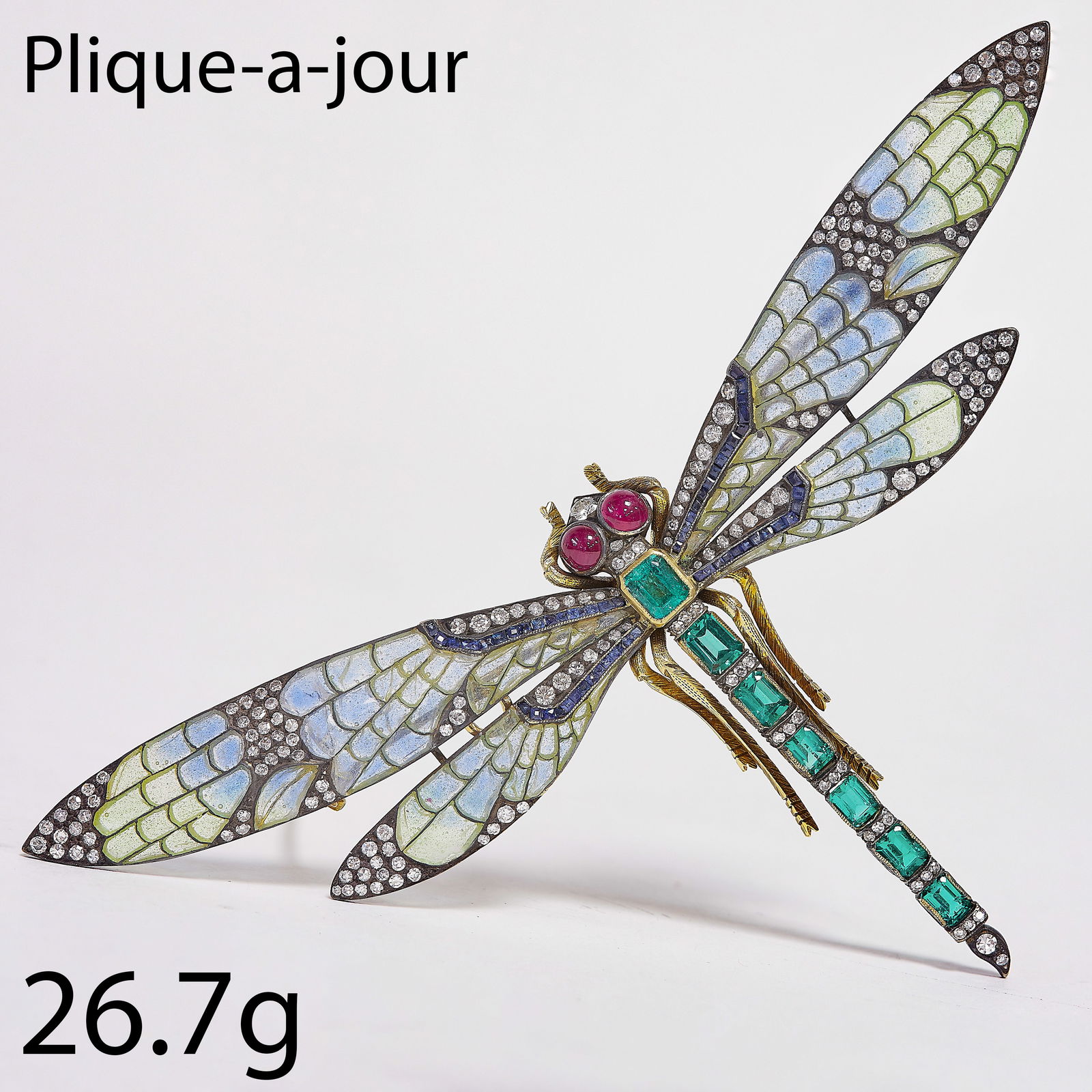 FINE ANTIQUE PLIQUE A JOUR ENAMEL, EMERALD, RUBY SAPPHIRE AND DIAMOND DRAGONFLY BROOCH: FINE ANTIQUE PLIQUE A JOUR ENAMEL, EMERALD, RUBY SAPPHIRE AND DIAMOND DRAGONFLY BROOCH,26.7 grams.The body and tail set with fine and vibrant emeralds.The wings with multi colour plique a jour enamel,