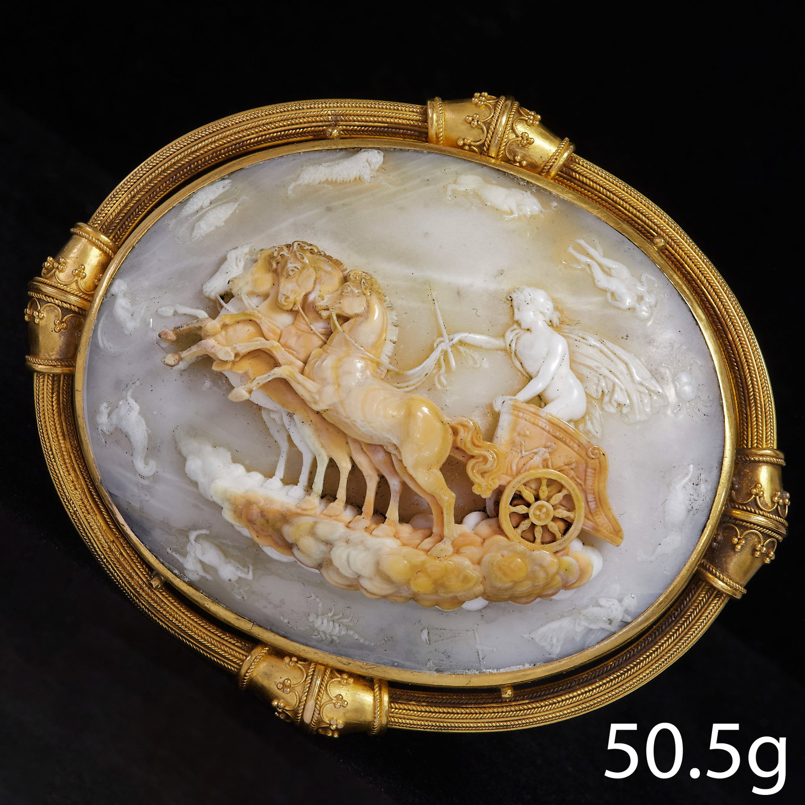 FINE AND RARE LARGE CAMEO IN GOLD MOUNT: FINE AND RARE LARGE CAMEO IN GOLD MOUNT,50.5 grams, High carat gold.The large cameo depicting a woman in a chariot, pulled by 4 horses.Surrounded with the 12 zodiac signs.The surmount with fine granul