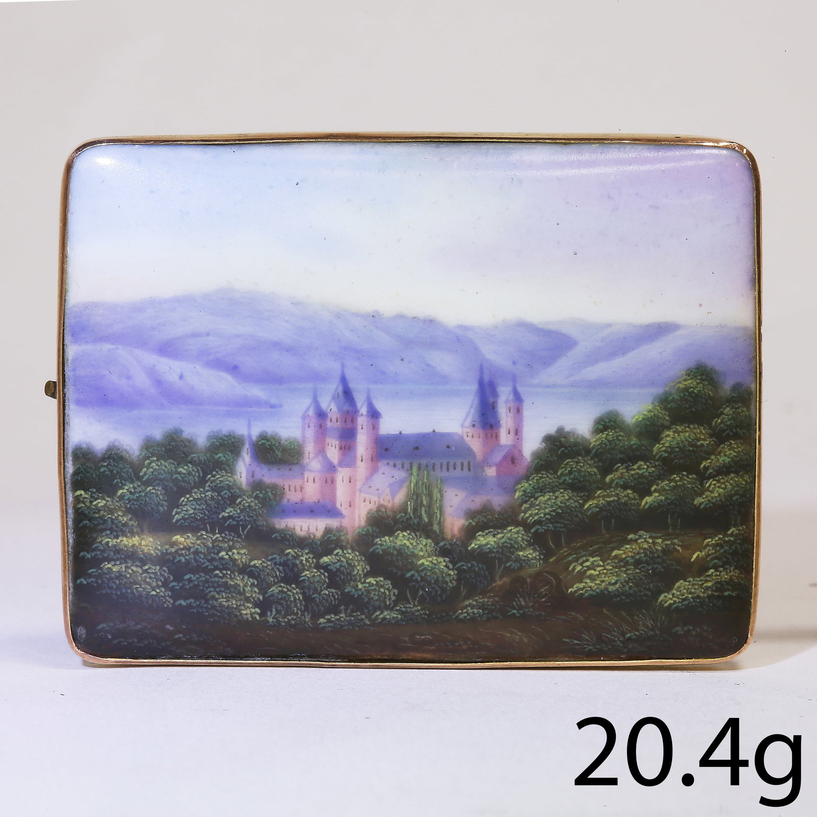 PORCELAIN PLAQUE GOLD BROOCH: PORCELAIN PLAQUE GOLD BROOCH,20.4 grams.The porcelain plaque depicting a castle in a forest.W. 5.4 cm.