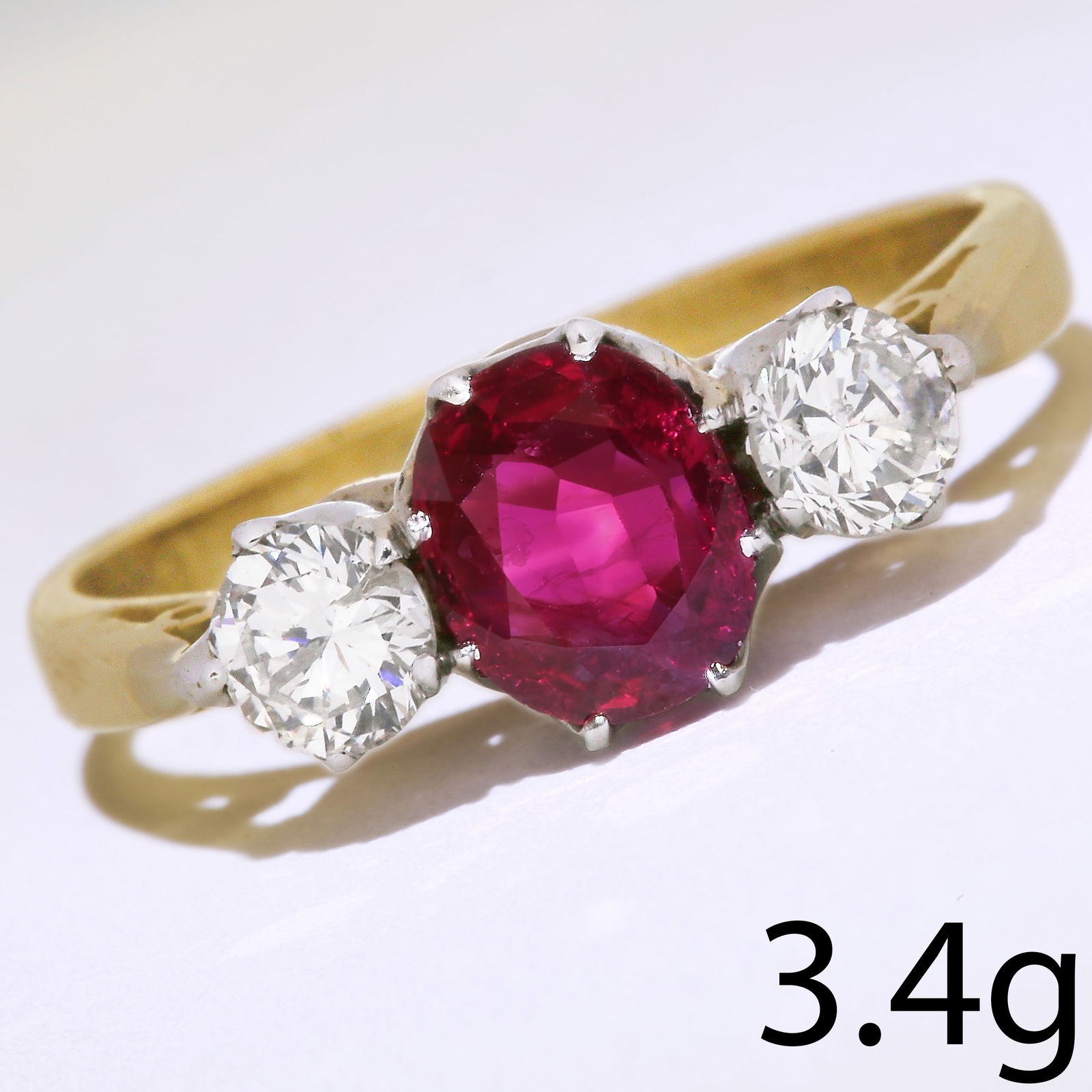 RUBY AND DIAMOND 3-STONE RING: RUBY AND DIAMOND 3-STONE RING,3.4 grams. 18 ct. gold.Gemstones totalling approx. 1.40 ct.Vibrant ruby,Diamonds bright and lively.Size M 1/2.
