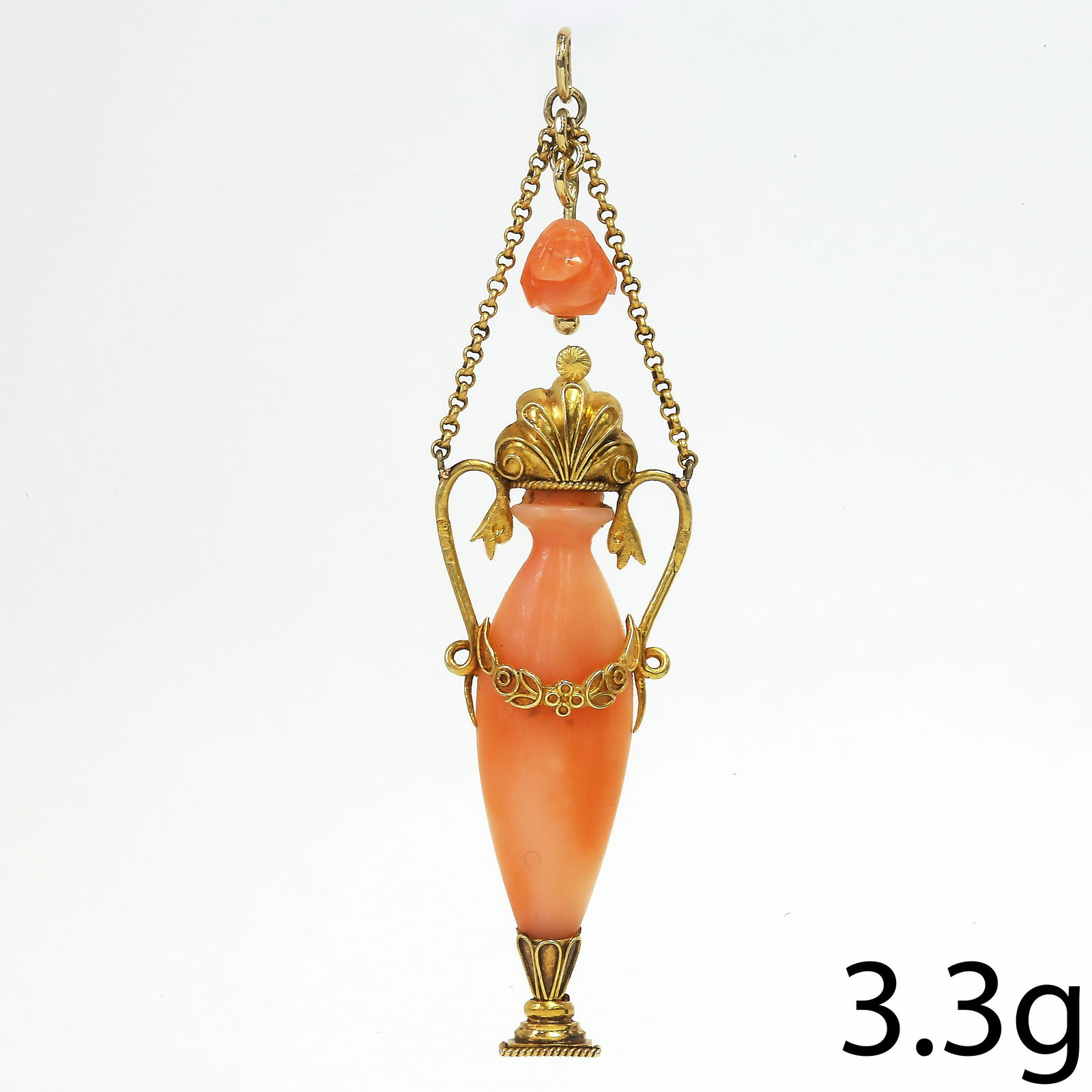 VICTORIAN ETRUSCAN REVIVAL CORAL AMPHORA PENDANT: VICTORIAN ETRUSCAN REVIVAL CORAL AMPHORA PENDANT,3.3 grams, testing high carat gold.The carved coral in the shape of an amphora.L. 6.1 cm.