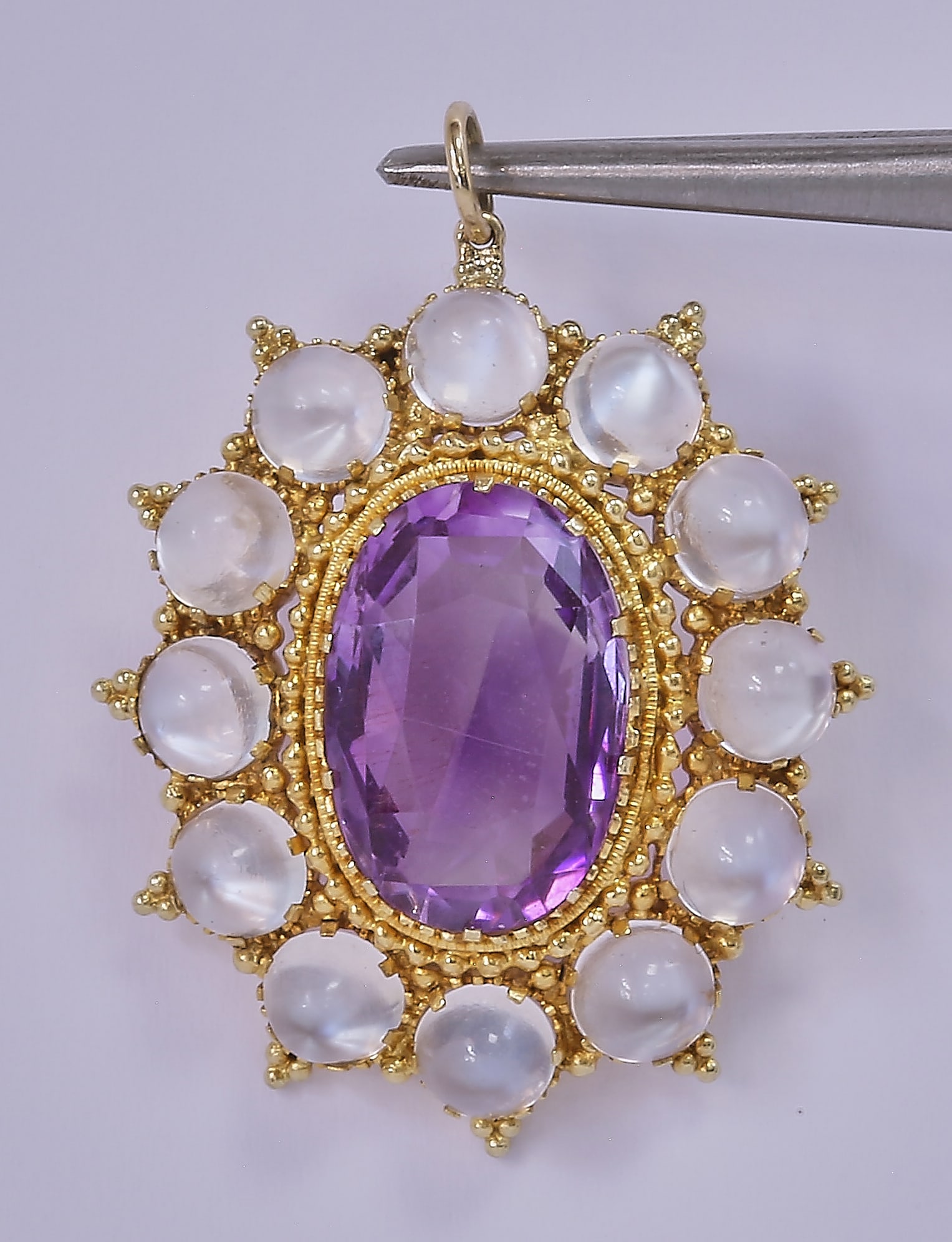 ANTIQUE AMETHYST AND MOONSTONE PENDANT: ANTIQUE AMETHYST AND MOONSTONE PENDANT5.3 grams, testing 18 carat gold. Fine gold work.L. 3.7 cm.
