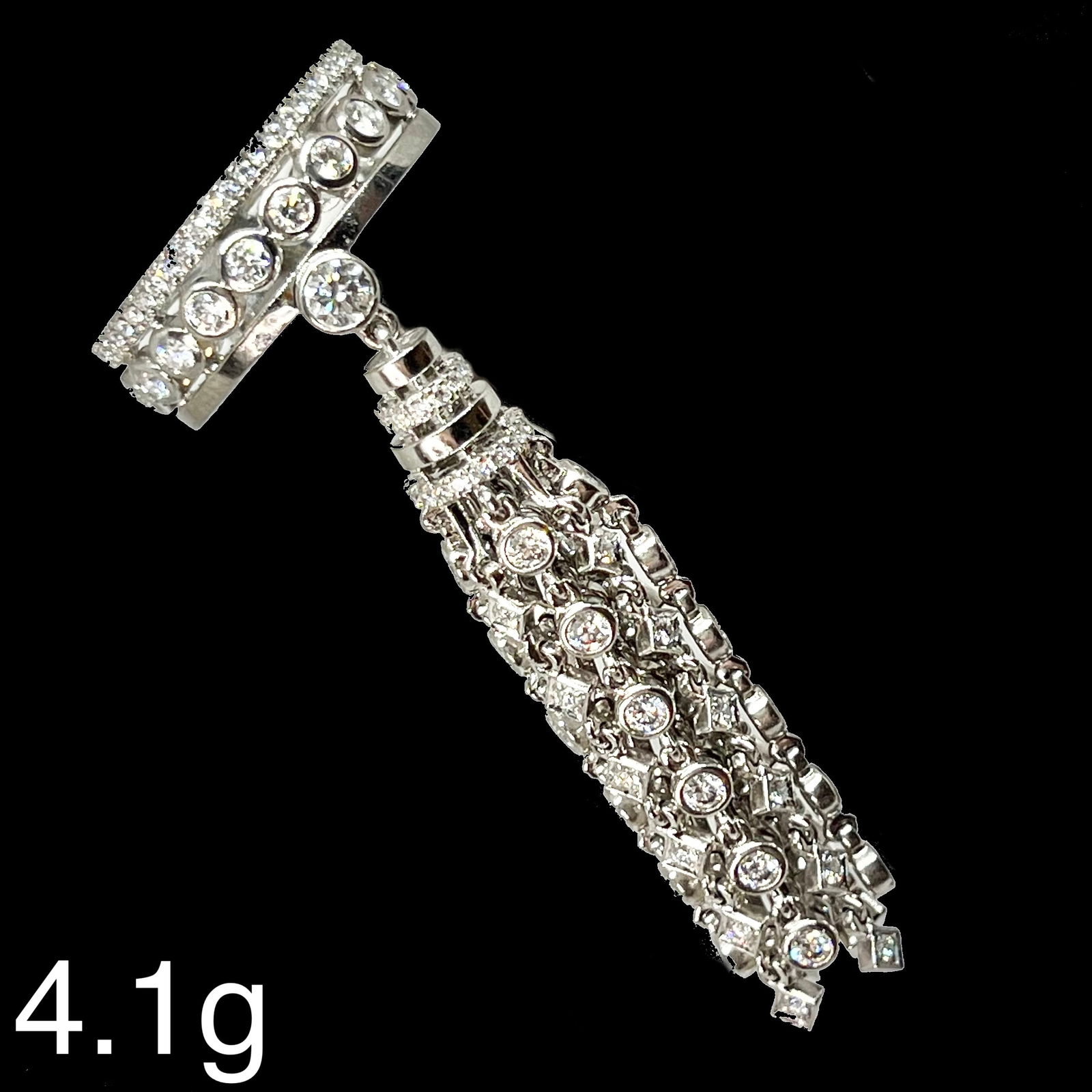 MESSIKA X KATE MOSS. UNUSUAL DIAMOND TASSEL RING: MESSIKA X KATE MOSS. UNUSUAL DIAMOND TASSEL RING,14.1 grams, 18 ct. gold.Diamond ring with unusual diamond set tassel drop.Signed Messika X Kate Moss.Size H.