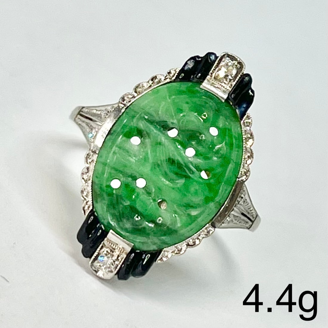 ART-DECO JADE DIAMOND AND ENAMEL RING: ART-DECO JADE DIAMOND AND ENAMEL RING,4,4 grams, testing platinum.Fine carved green jade.Diamonds bright and lively.Black enamel accents.Size P.