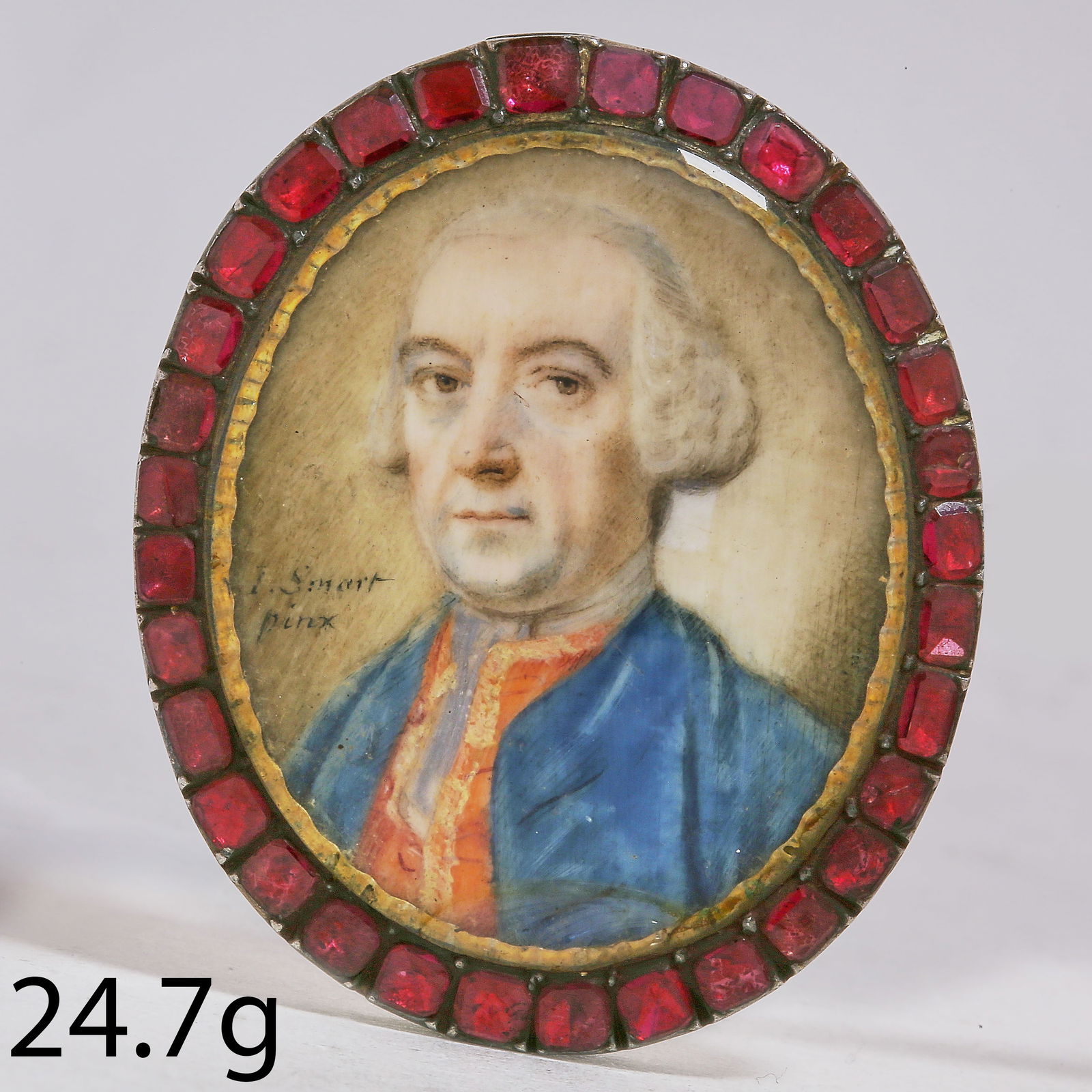 JOHN SMART (1741-1811), PORTRAIT MINIATURE OF A GENTLEMAN: JOHN SMART (1741-1811), PORTRAIT MINIATURE OF A GENTLEMAN,24.7 grams.The gentleman wearing a blue coat and red waistcoat.The surmount set with garnets.Signed I Smart Pinx.L. 4.7 cm.