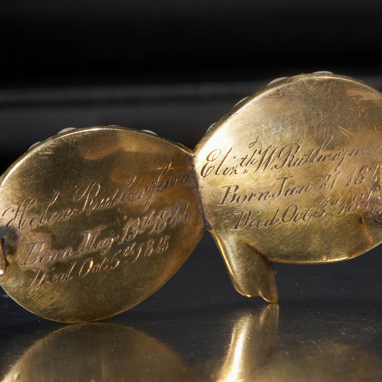 VICTORIAN ENAMEL AND PEARL MEMORI GOLD BROOCH: VICTORIAN ENAMEL AND PEARL MEMORI GOLD BROOCH,Swirled entwined design.Pearls assumed to be natural.Enamel in good condition.The back with text and multiple dates, 1844 - 1847W. 3.9 cm.8.5 grams.