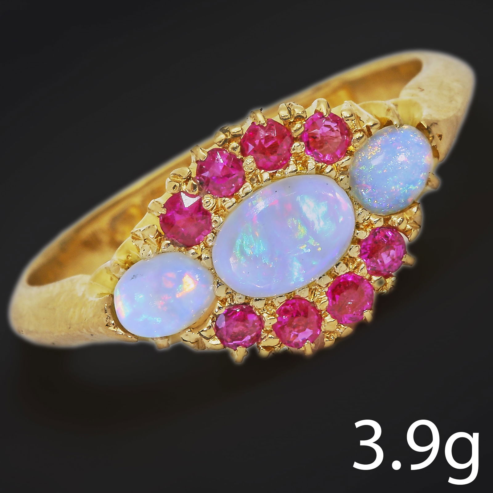 OPAL AND RUBY RING: OPAL AND RUBY RING,3.9 grams, 18 ct. gold.Vibrant opals with good play of colour.Rich and vibrant rubies.Size M 1/2.