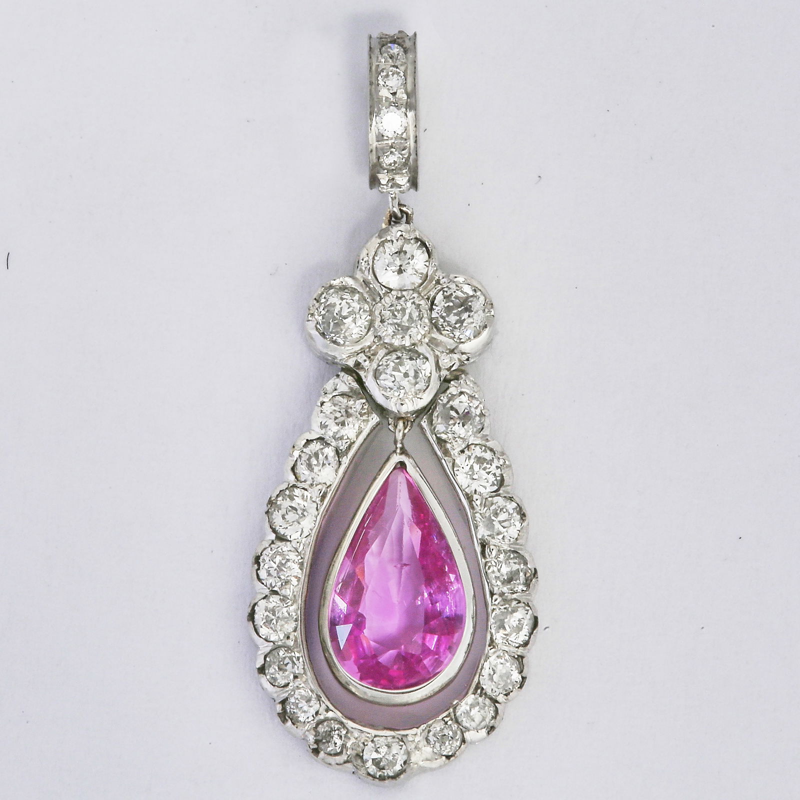 UNUSUAL PINK SAPPHIRE AND DIAMOND PENDANT: UNUSUAL PINK SAPPHIRE AND DIAMOND PENDANT,testing high carat gold.Set to both front and back with diamonds.Diamonds totalling approx. 1.10 ct.Rich and vibrant pink sapphire of approx. 0.75 ct.L. 2.7
