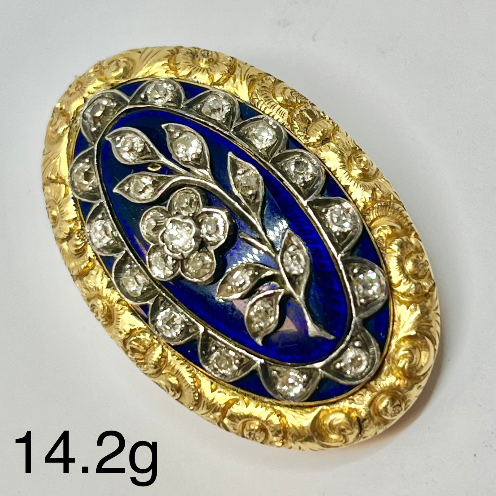 GEORGIAN DIAMOND LOCKET BACK BROOCH: GEORGIAN DIAMOND LOCKET BACK BROOCH,14.2 grams, testing high carat gold.Diamonds bright and lively, with a diamond set flower to the centre and further diamond border.Locket back, with text and