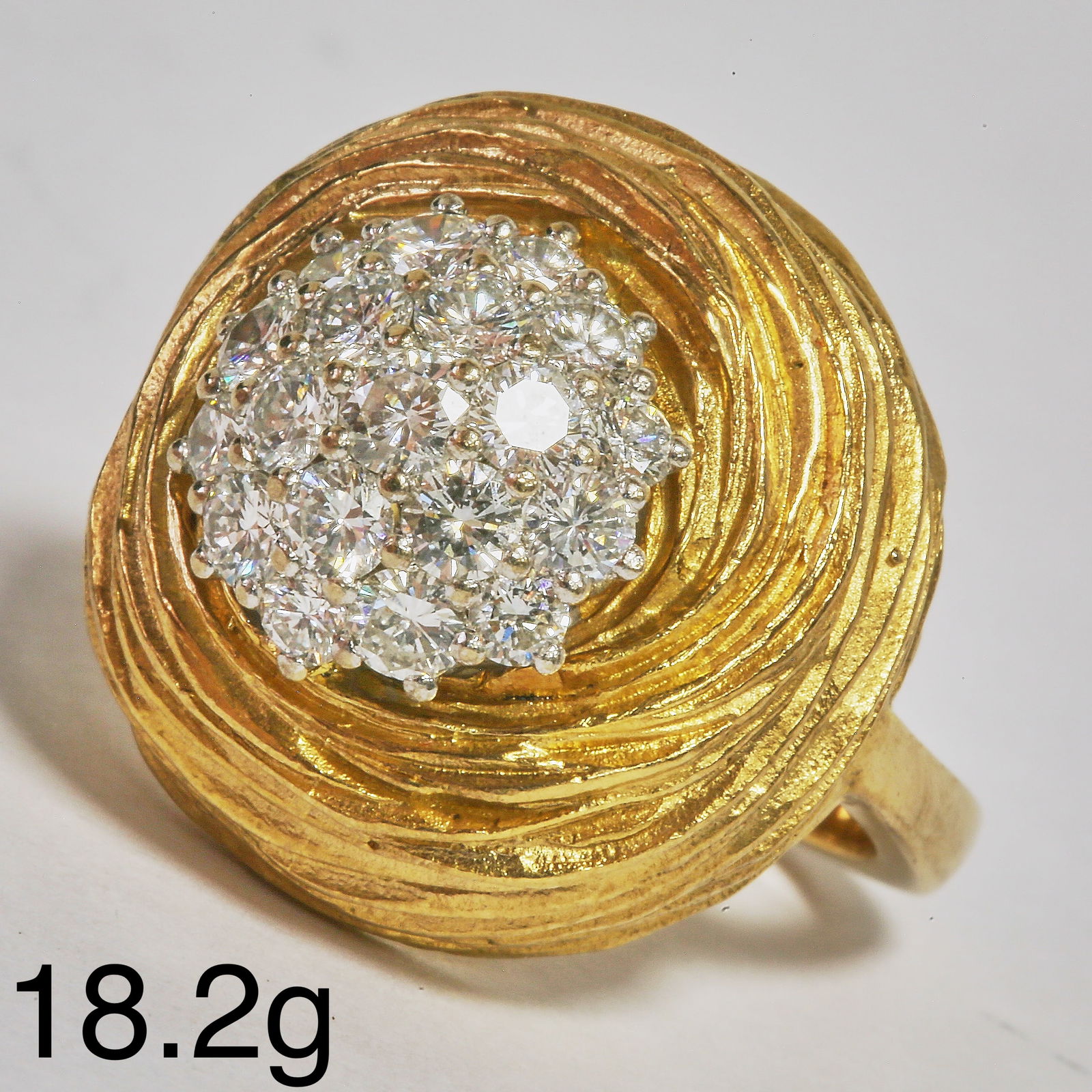 MODERNIST DIAMOND CLUSTER RING: MODERNIST DIAMOND CLUSTER RING,18.2 grams, 18 ct. gold.Diamonds bright and lively, totalling approx. 2 ct.Size O.