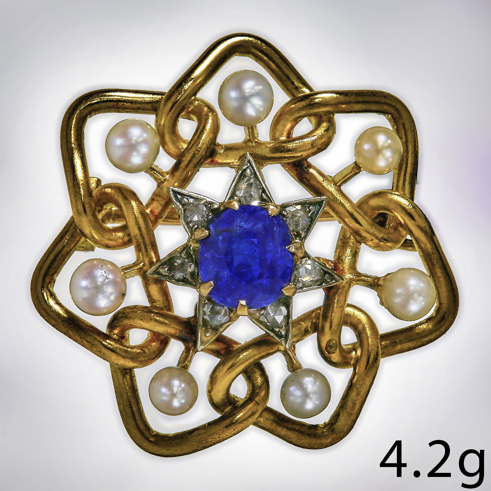 ANTIQUE SAPPHIRE PEARL AND DIAMOND STAR BROOCH: ANTIQUE SAPPHIRE PEARL AND DIAMOND STAR BROOCH,4,2 grams, testing 18 ct. gold.Vibrant sapphire of approx. 1.06 ct.Diamonds bright and lively.Pearls untested.W. 1,3 cm.