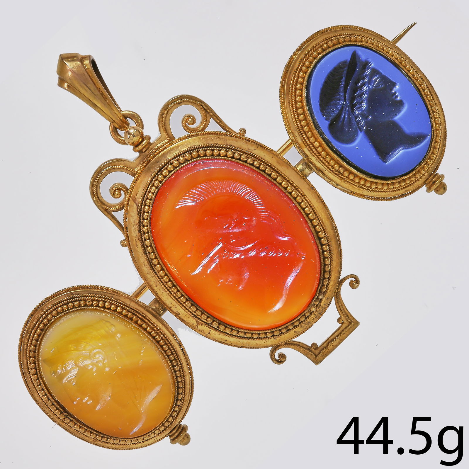 FANTASTIC ETRUSCAN REVIVAL LARGE INTAGLIO BROOCH/PENDANT: FANTASTIC ETRUSCAN REVIVAL LARGE INTAGLIO BROOCH/PENDANT.44.5 grams, 18 ct. gold. French.3 carved hard stone intaglio's.The largest one depicting Athena, goddess of war.All 3 fine carved.W. 8.6 cm.rem