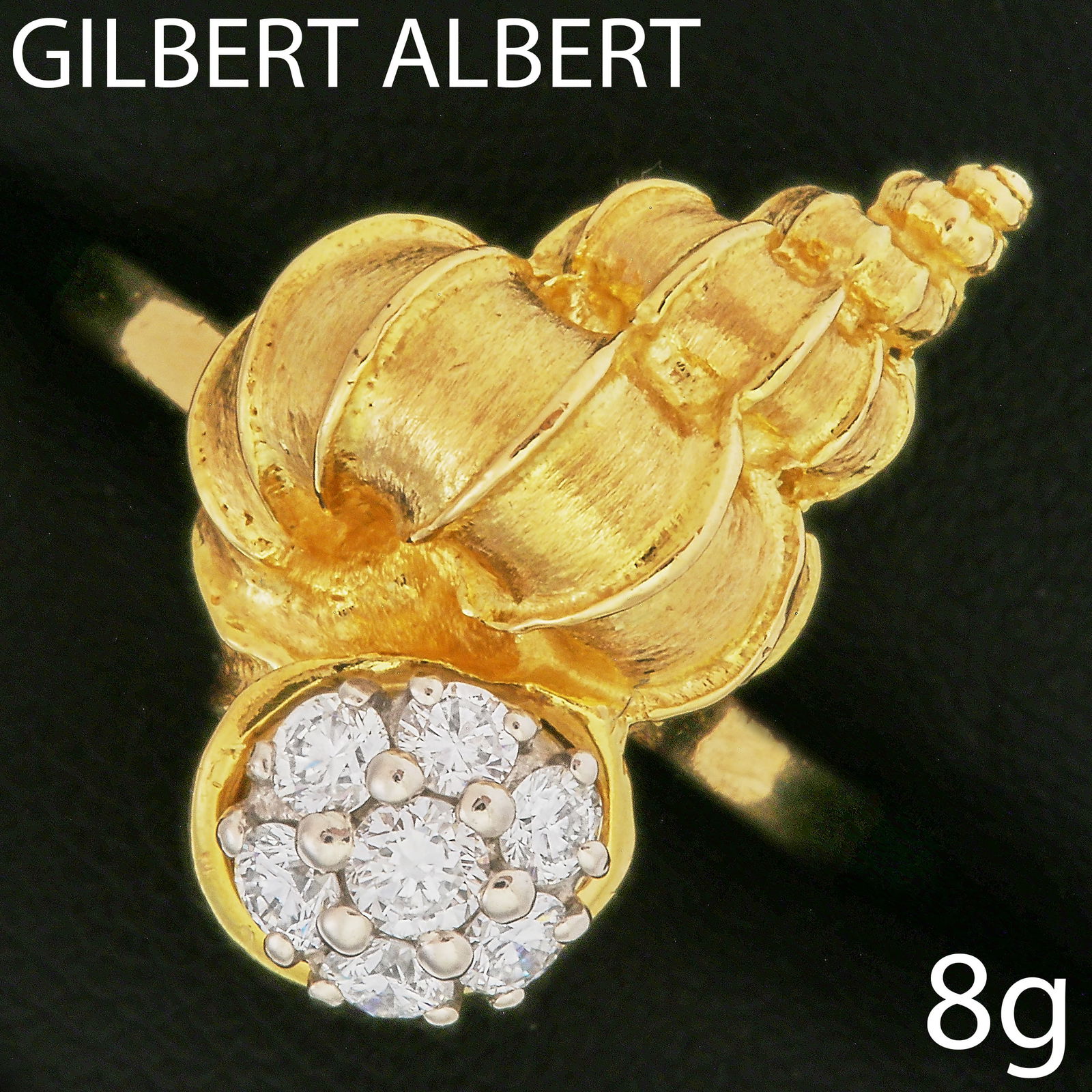 GILBERT ALBERT, DIAMOND SHELL RING: GILBERT ALBERT, DIAMOND SHELL RING,8 grams, testing high carat gold.The top designed as a shell, set with diamonds.Makers mark Gilbert Albert.Size M 1/2.