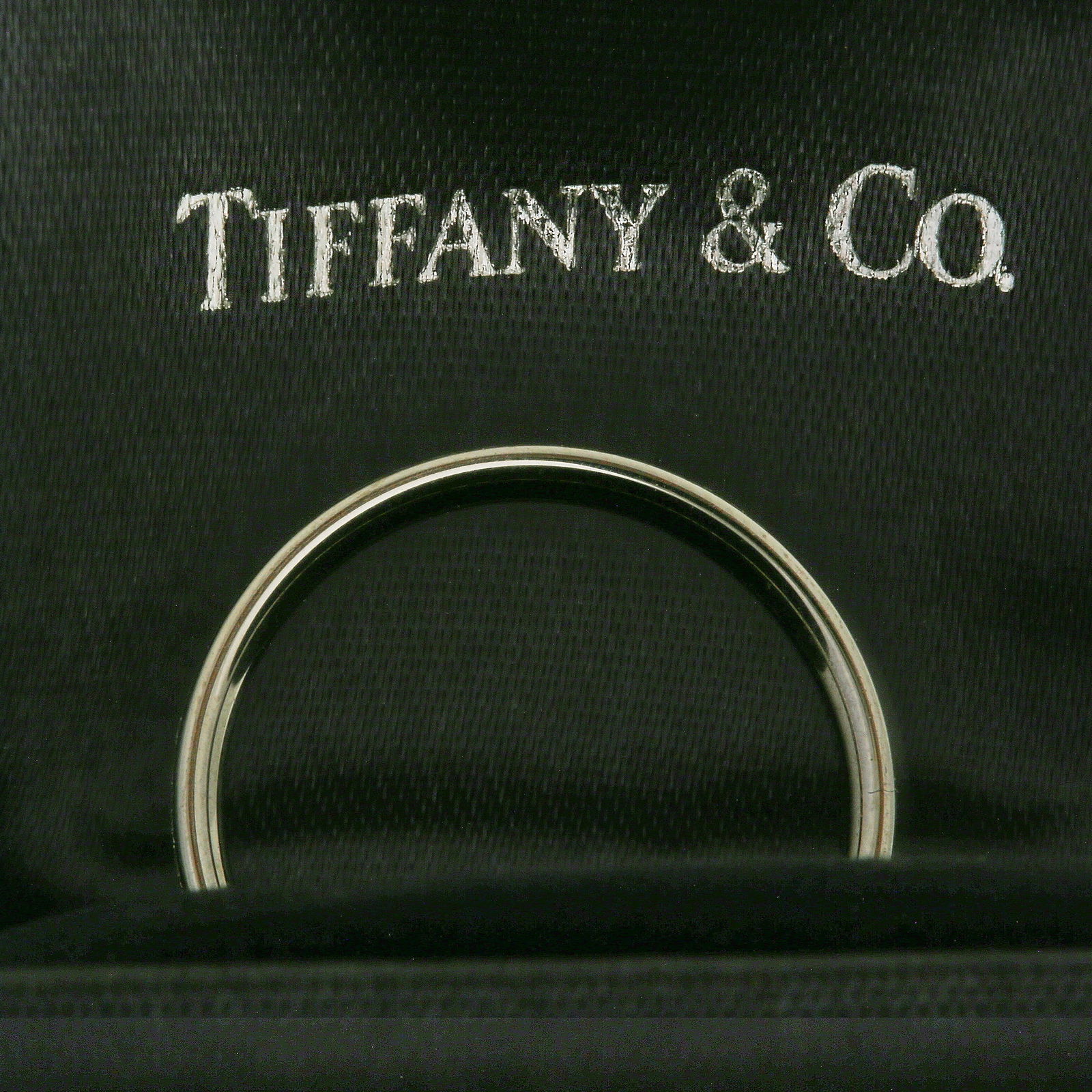 TIFFANY & CO., DIAMOND ETERNITY RING: TIFFANY & CO., DIAMOND ETERNITY RING2.6 grams, marked 18 carat gold. Bright and lively diamonds. Quality craftsmanship. Size K 1/2. In Tiffany & Co. box and outer box.