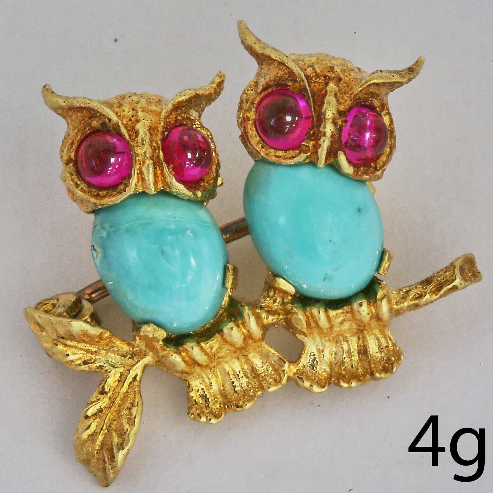 SWEET TURQUOISE AND RUBY DOUBLE OWL BROOCH: SWEET TURQUOISE AND RUBY DOUBLE OWL BROOCH,4 grams, testing high carat gold.Cabochon cut ruby eyes.W. 2.1 cm.