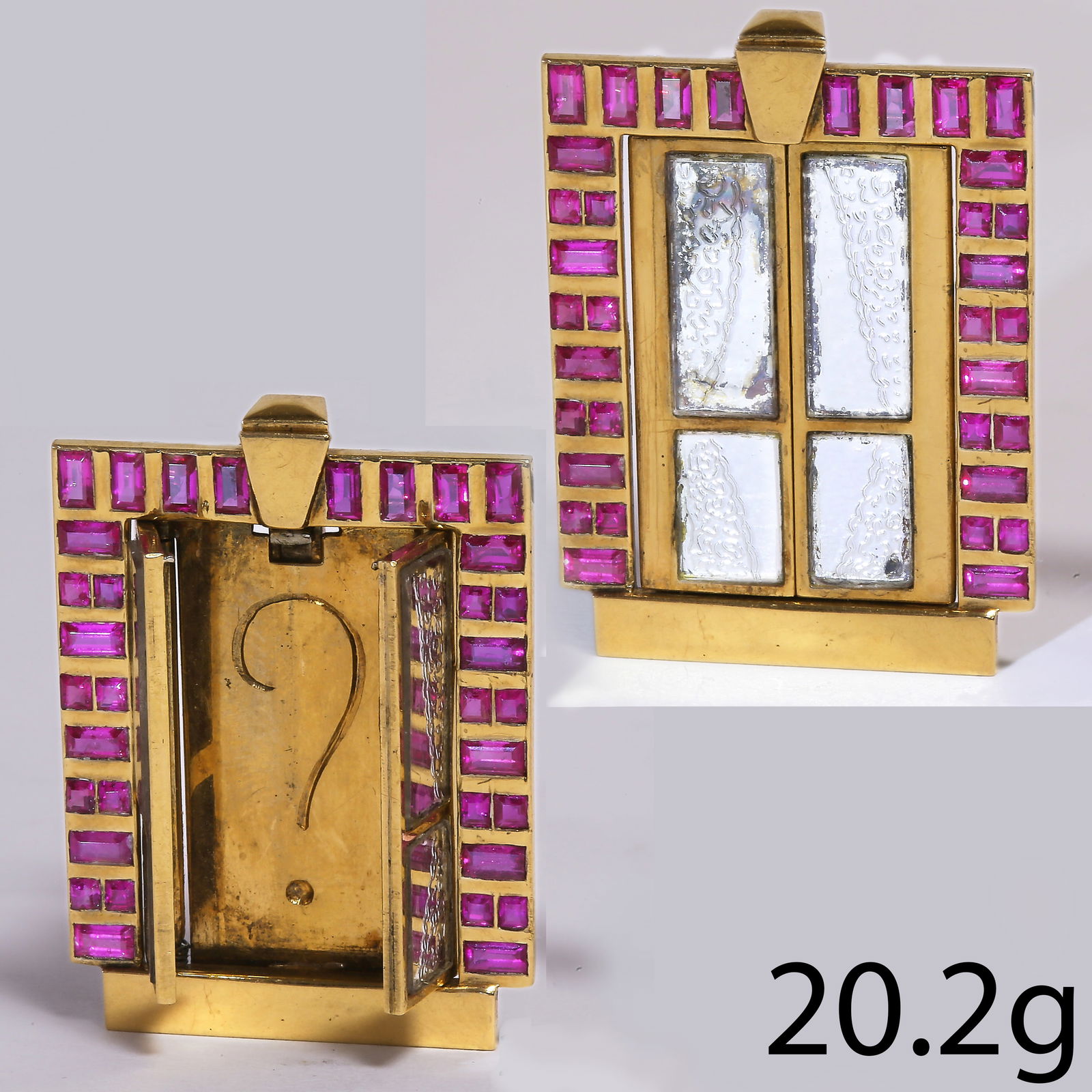 FRENCH RUBY CLIP BROOCH, OPENING WINDOW BROOCH: FRENCH RUBY CLIP BROOCH, OPENING WINDOW BROOCH,20.2 grams, 18 ct. gold.The window outlined with rubies.When you press the button on top, the windows open to reveal the question mark on the inside.L. 3
