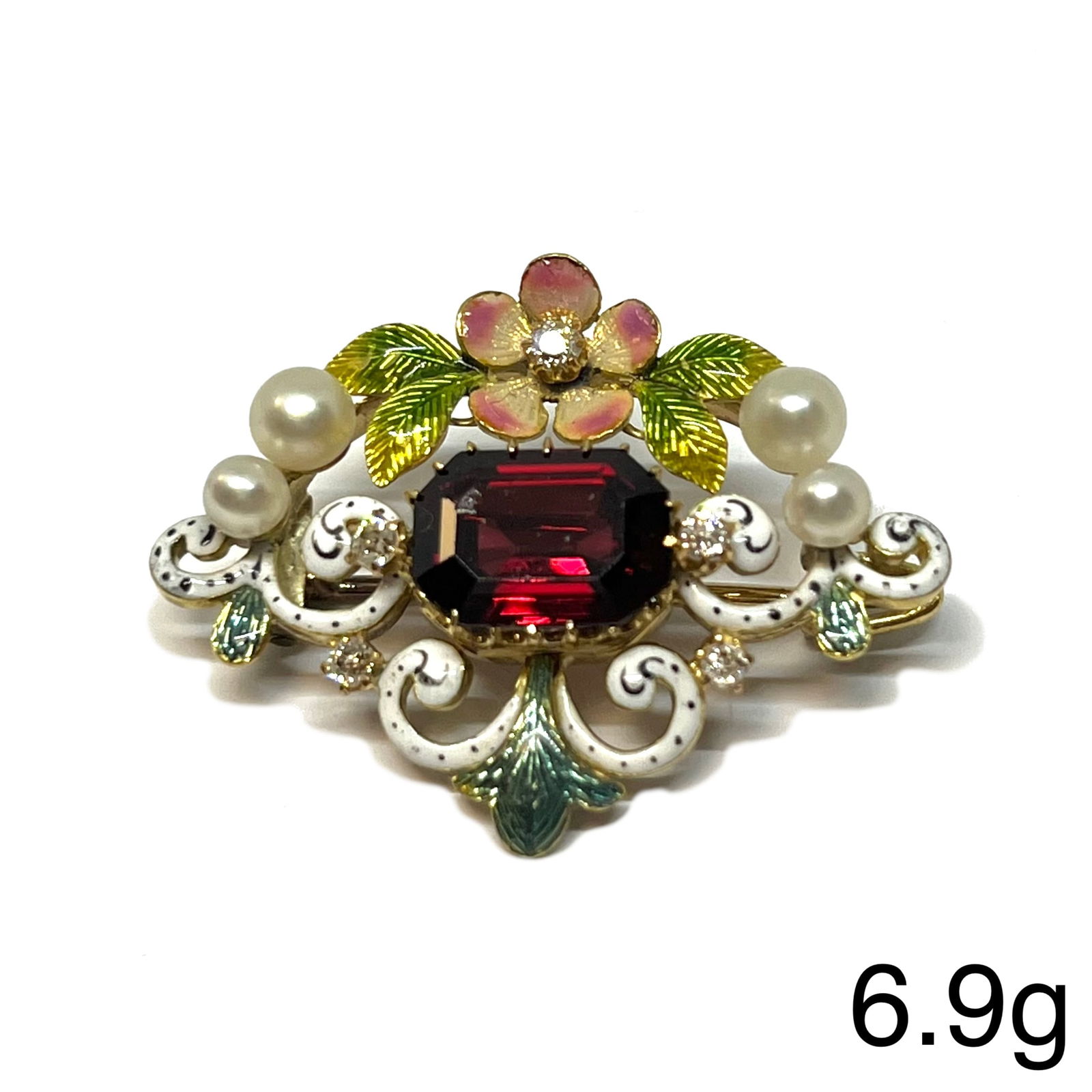 UNUSUAL ANTIQUE ENAMEL, PEARL, DIAMOND AND GARNET BROOCH: UNUSUAL ANTIQUE ENAMEL, PEARL, DIAMOND AND GARNET BROOCH,6.9 grams, testing high carat gold.Fine multi colour enamel.Diamonds bright and lively.Rich and vibrant garnet.W. 3.2 cm.Giuliano?