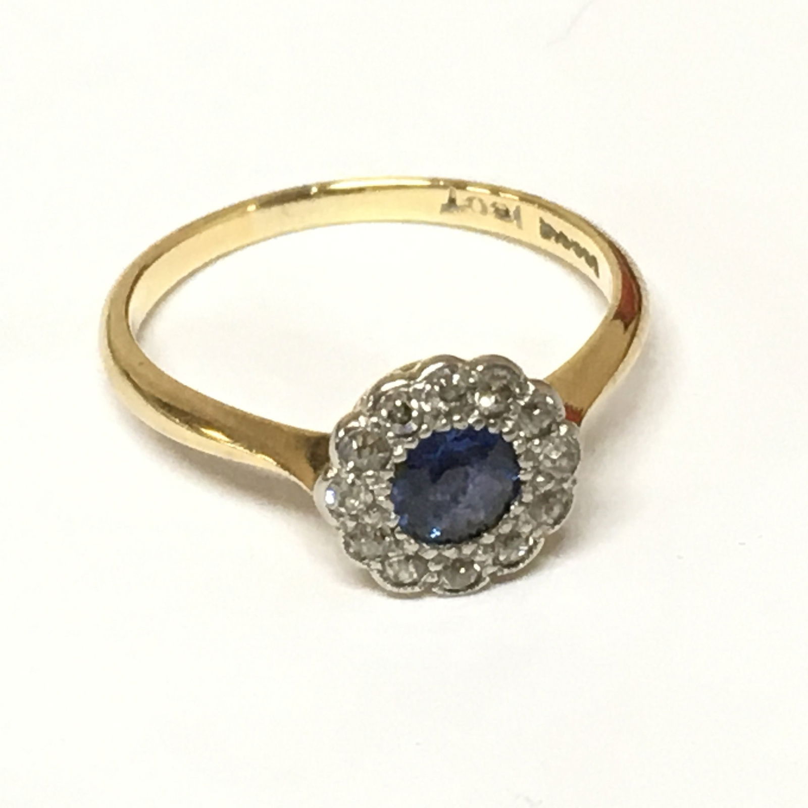 SAPPHIRE AND DIAMOND CLUSTER RING: SAPPHIRE AND DIAMOND CLUSTER RING,18 ct. gold.Vibrant sapphire.bright and lively diamonds.Size N 1/2.