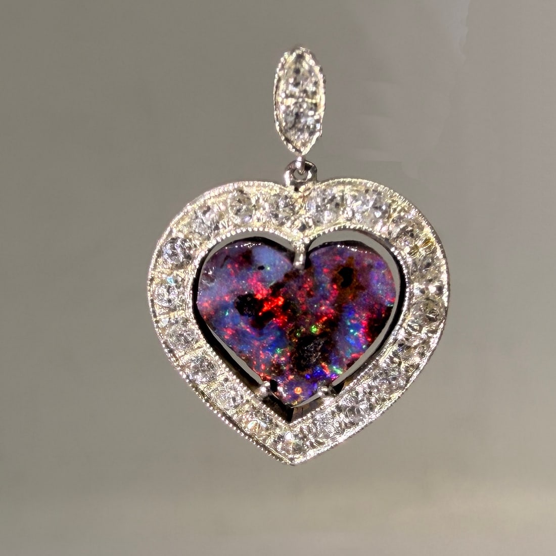 LOVELY OPAL AND DIAMOND HEART PENDANT: LOVELY OPAL AND DIAMOND HEART PENDANT,Vibrant opal with good play of colour including red.Diamonds bright and lively.L. 1,9 cm.