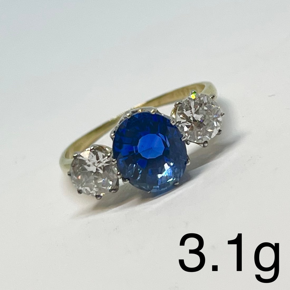 FINE CEYLON SAPPHIRE AND DIAMOND 3-STONE RING: FINE CEYLON SAPPHIRE AND DIAMOND 3-STONE RING,3,1 grams, 18 ct. gold.Rich and vibrant sapphire of approx. 3.20 ct. (Verbal GCS, Ceylon origin).Diamonds bright and lively, totalling approx. 0.94 ct.Siz
