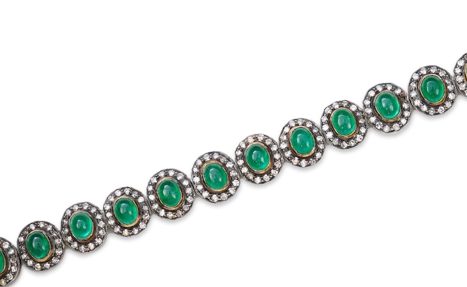 EMERALD AND DIAMOND CLUSTER BRACELET: EMERALD AND DIAMOND CLUSTER BRACELET,16.2 grams, testing high carat gold and silver.Rich and vibrant cabochon cut emeralds, totalling approx. 7.60 ct.Approx. 294 diamonds, bright and lively.L. 17.5 cm