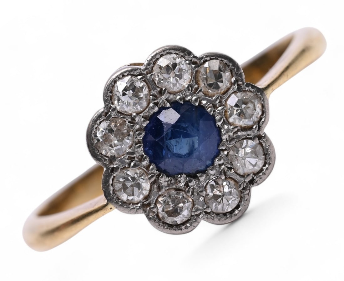 EDWARDIAN SAPPHIRE AND DIAMOND CLUSTER RING: EDWARDIAN SAPPHIRE AND DIAMOND CLUSTER RING,3,6 grams, testing high carat gold.Vibrant sapphire of approx. 0.60 ct.Diamonds bright and lively.Size N.