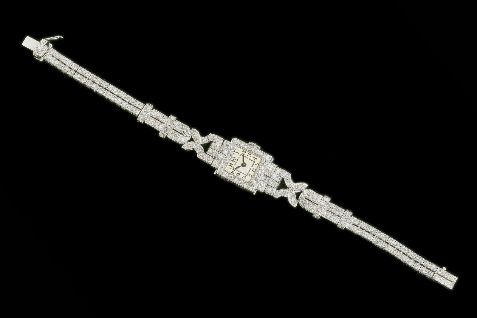 DIAMOND WRISTWATCH: DIAMOND WRISTWATCH,26.1 grams, testing platinum.Bright and lively diamonds on the bezel, shoulders and strap, totalling approx. 4 ct.Manual winding.L. 17 cm.Movement running at time of cataloguing thi