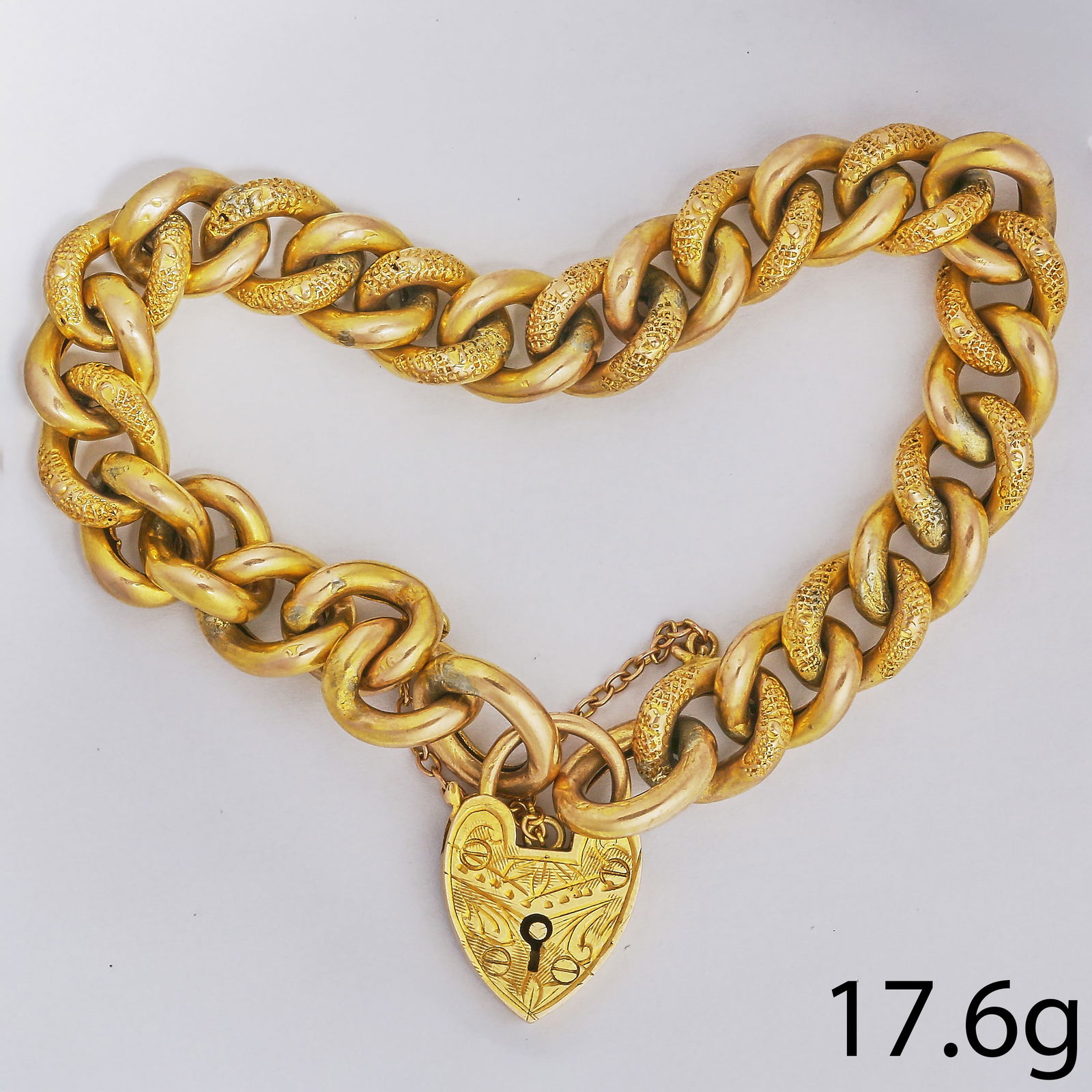 CURBLINK GOLD BRACELET WITH HEART PADLOCK CLASP: CURBLINK GOLD BRACELET WITH HEART PADLOCK CLASP,17,6 grams.Links of part textured design.L. 20 cm.