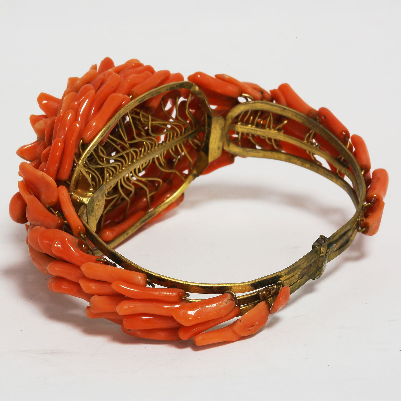 FINE ANTIQUE CORAL BANGLE: FINE ANTIQUE CORAL BANGLE,39.7 grams.The carved corals shaped like a large flower head, with petals on the sides. Inner diam. 5.9 cm.W. 3.9 cm.
