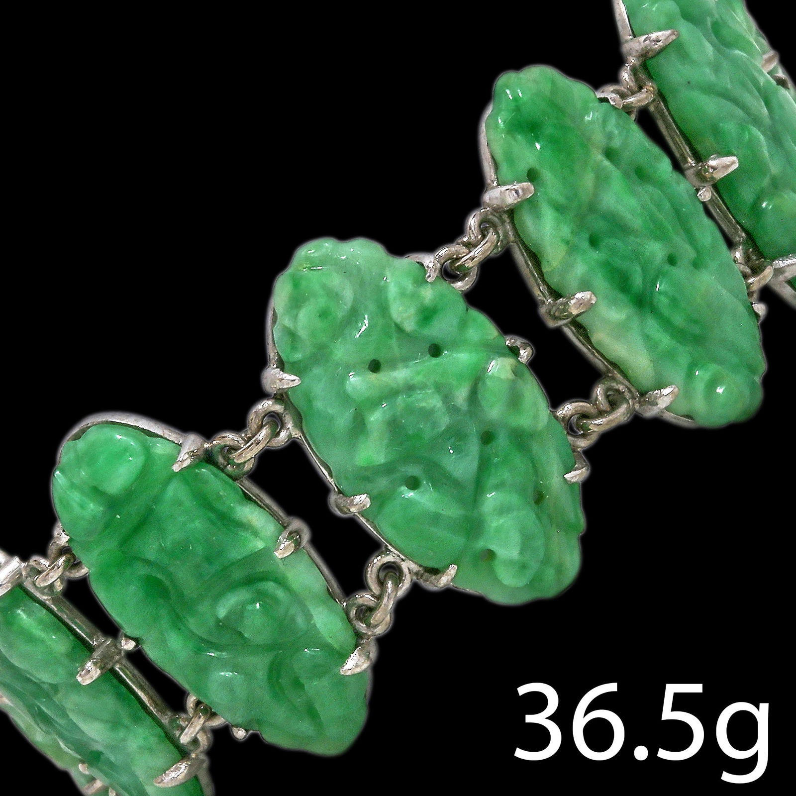 ANTIQUE JADE PANEL BRACELET: ANTIQUE JADE PANEL BRACELET,36.5 grams. 18 ct. gold.11 carved graan jade plauqes, with floral carving.L. 17.5 cm.