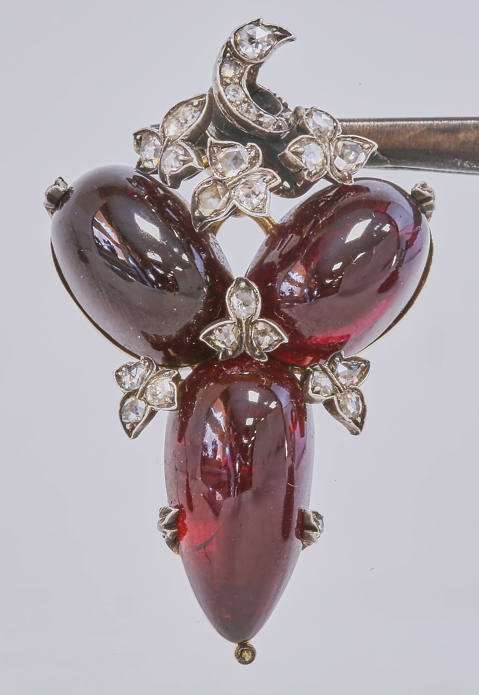 ANTIQUE VICTORIAN GARNET AND DIAMOND BROOCH: ANTIQUE VICTORIAN GARNET AND DIAMOND BROOCH,11,4 grams, testing high carat gold and silver.Vibrant cabochon cut garnets.Diamonds bright and lively.Lovely engraved backs.L. 4.1 cm.
