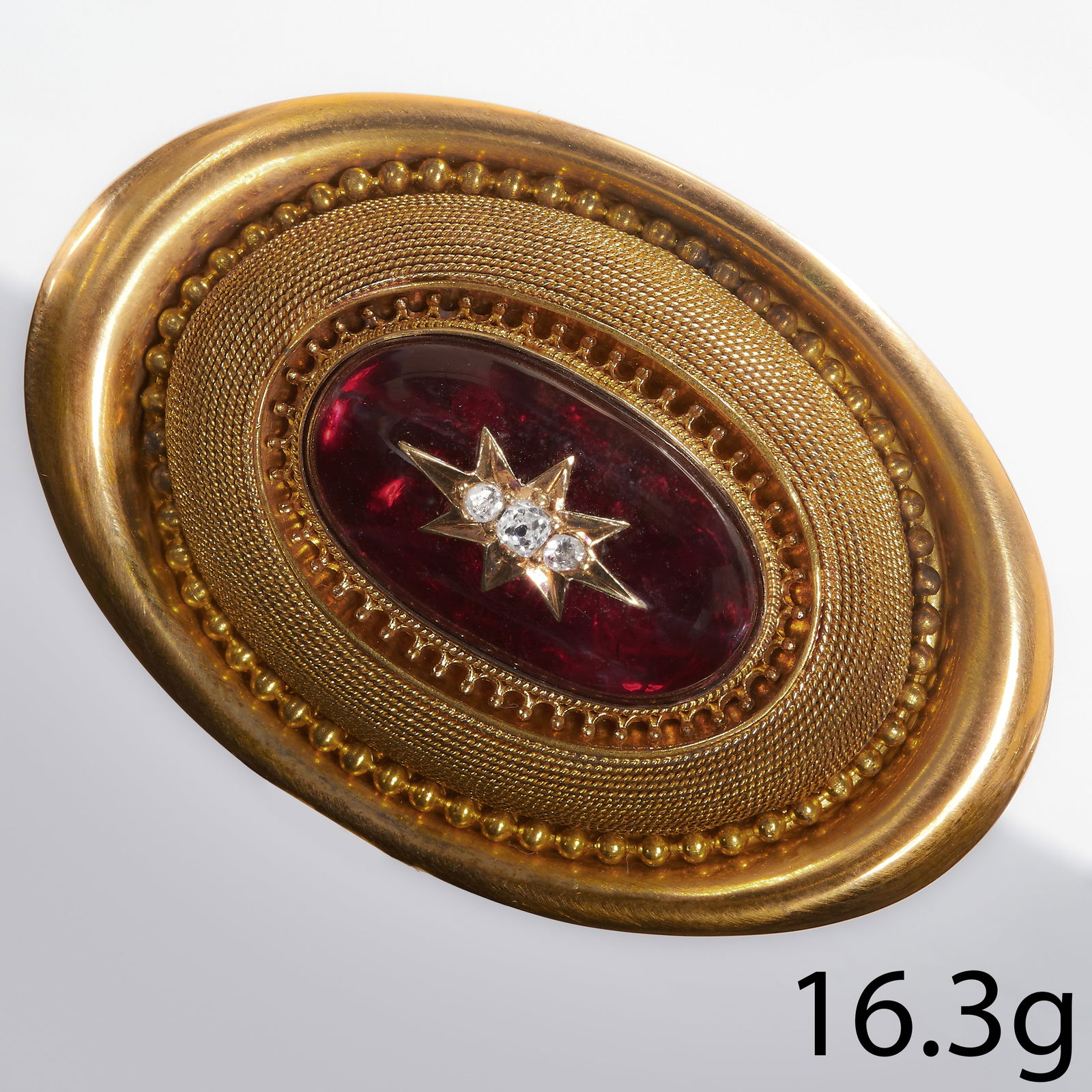 VICTORIAN GARNET AND DIAMOND PENDANT: VICTORIAN GARNET AND DIAMOND PENDANT,15.6 grams, testing 15 ct. gold.Vibrant cabochon cut garnet.Locket back.L. 4.7 cm.