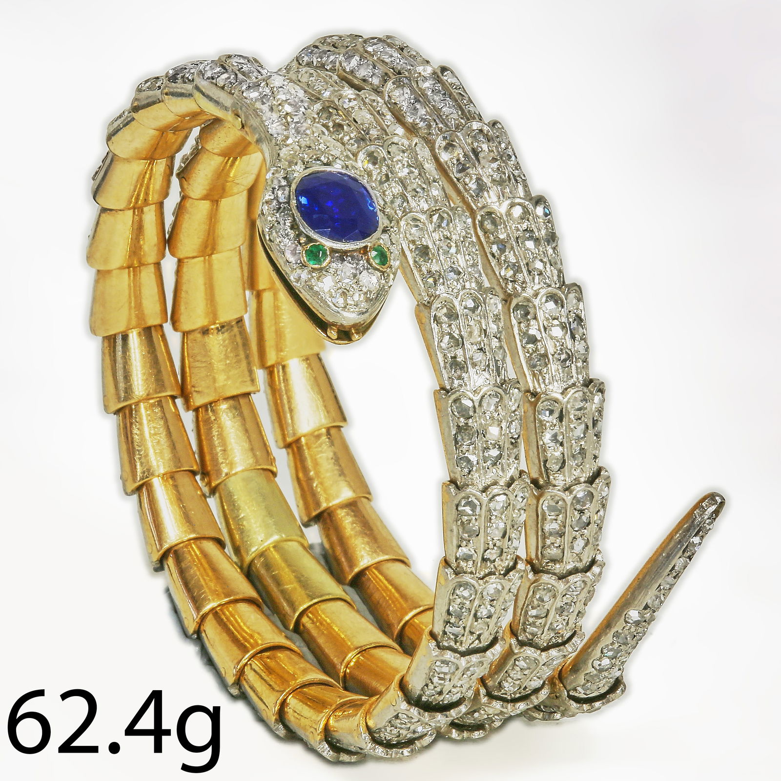 IMPORTANT VICTORIAN DIAMOND AND SAPPHIRE SPRING SNAKE BANGLE: IMPORTANT VICTORIAN DIAMOND AND SAPPHIRE SPRING SNAKE BANGLE,62,4 grams.The snake of 3 coil design.Fully set with bright and lively diamonds.The head of the snake set with a rich and vibrant sapphire.