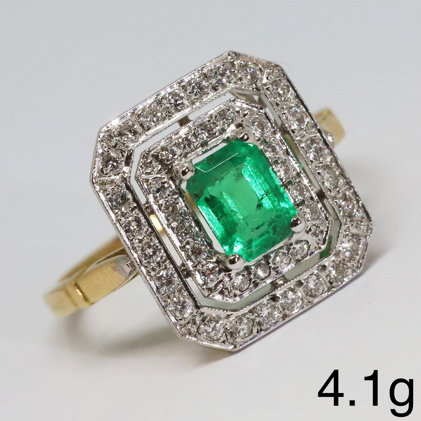 EMERALD AND DIAMOND CLUSTER RING: EMERALD AND DIAMOND CLUSTER RING,4.1 grams, testing high carat gold.Rich and vibrant emerald of approx. 0.95 ct.Diamonds bright and lively, totalling approx. 0.90 ct.Size Q 1/2.
