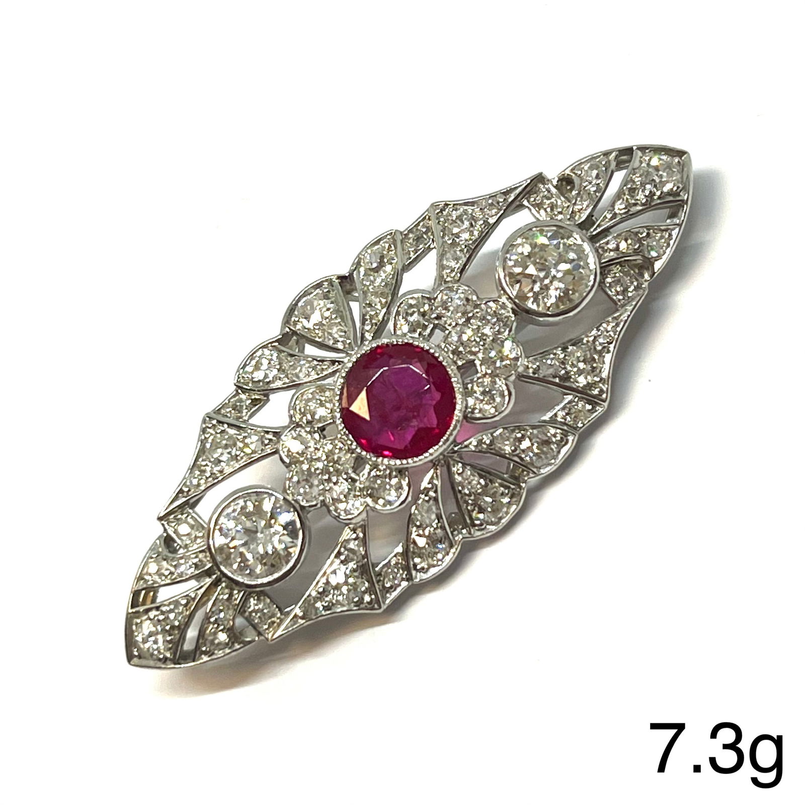 EDWARDIAN CERTIFICATED BURMA RUBY AND DIAMOND BROOCH: EDWARDIAN CERTIFICATED BURMA RUBY AND DIAMOND BROOCH,7,3 grams, testing high carat gold.Featuring a fine ruby if approx. 1. ct. (Certificated, Burma 'Mogok', No heat).Diamonds bright and lively,