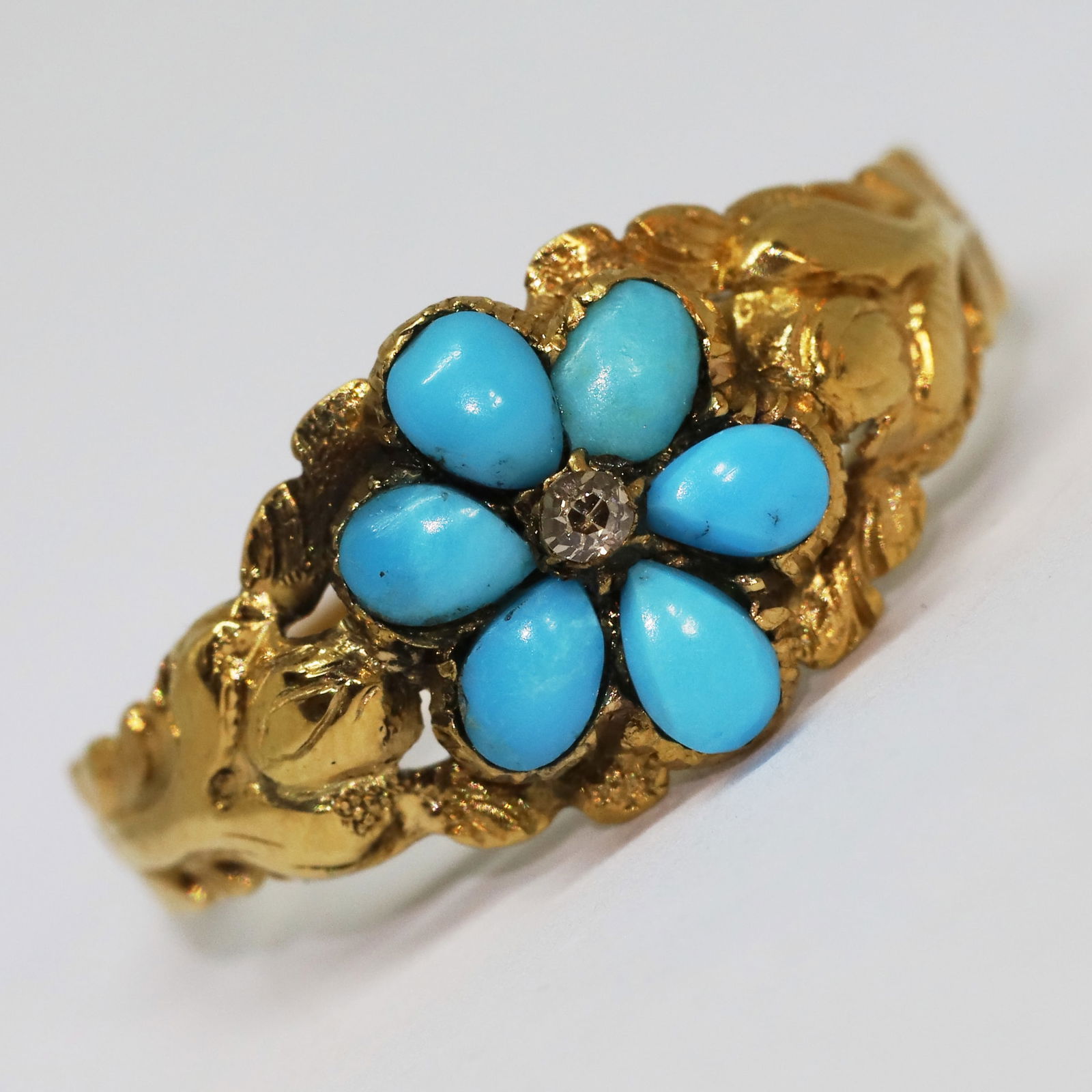 ANTIQUE TURQUOISE AND DIAMOND DAISY CLUSTER RING: ANTIQUE TURQUOISE AND DIAMOND DAISY CLUSTER RING,testing high carat gold.Vibrant turquoise.Lovely relief decorated shoulders.Locket back.Size O.