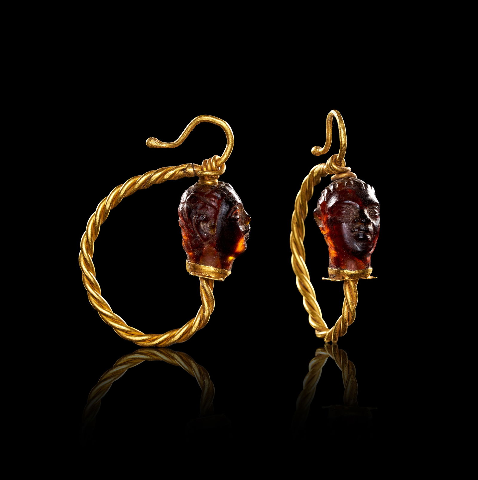 FANTASTIC PAIR OF ROMAN GOLD AND GARNET CARVED EARRINGS: FANTASTIC PAIR OF ROMAN GOLD AND GARNET CARVED EARRINGS,12.1 grams, testing high carat gold.By repute 2nd - 3rd Century AD.The earrings of twisted entwined wire design.Each featuring a fantastic