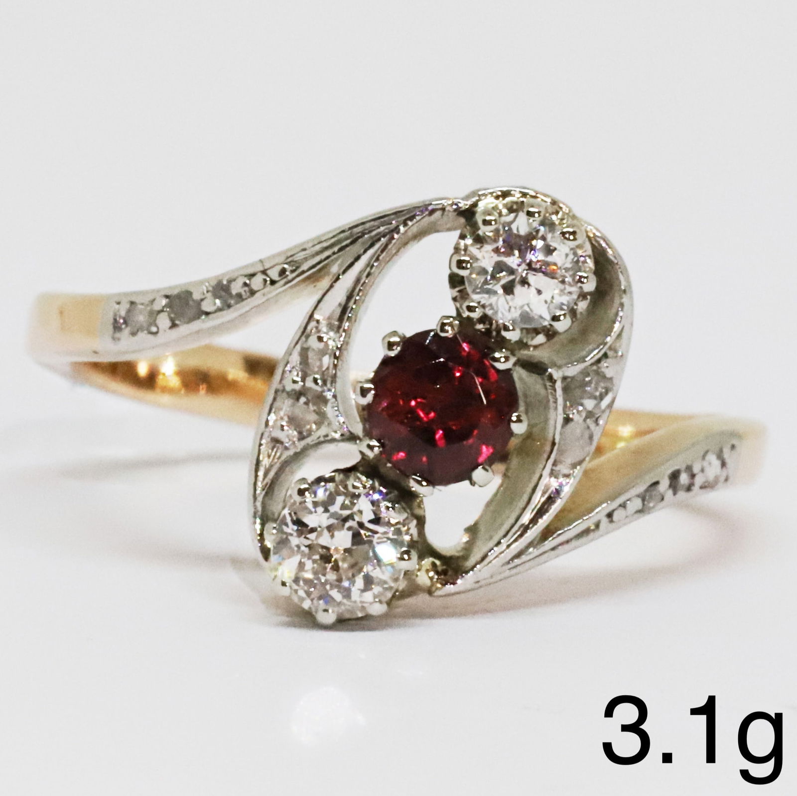 RUBY AND DIAMOND TWIST RING: RUBY AND DIAMOND TWIST RING,3,1 grams, testing high carat gold.Rich and vibrant ruby.Diamonds bright and lively.Size N 1/2.