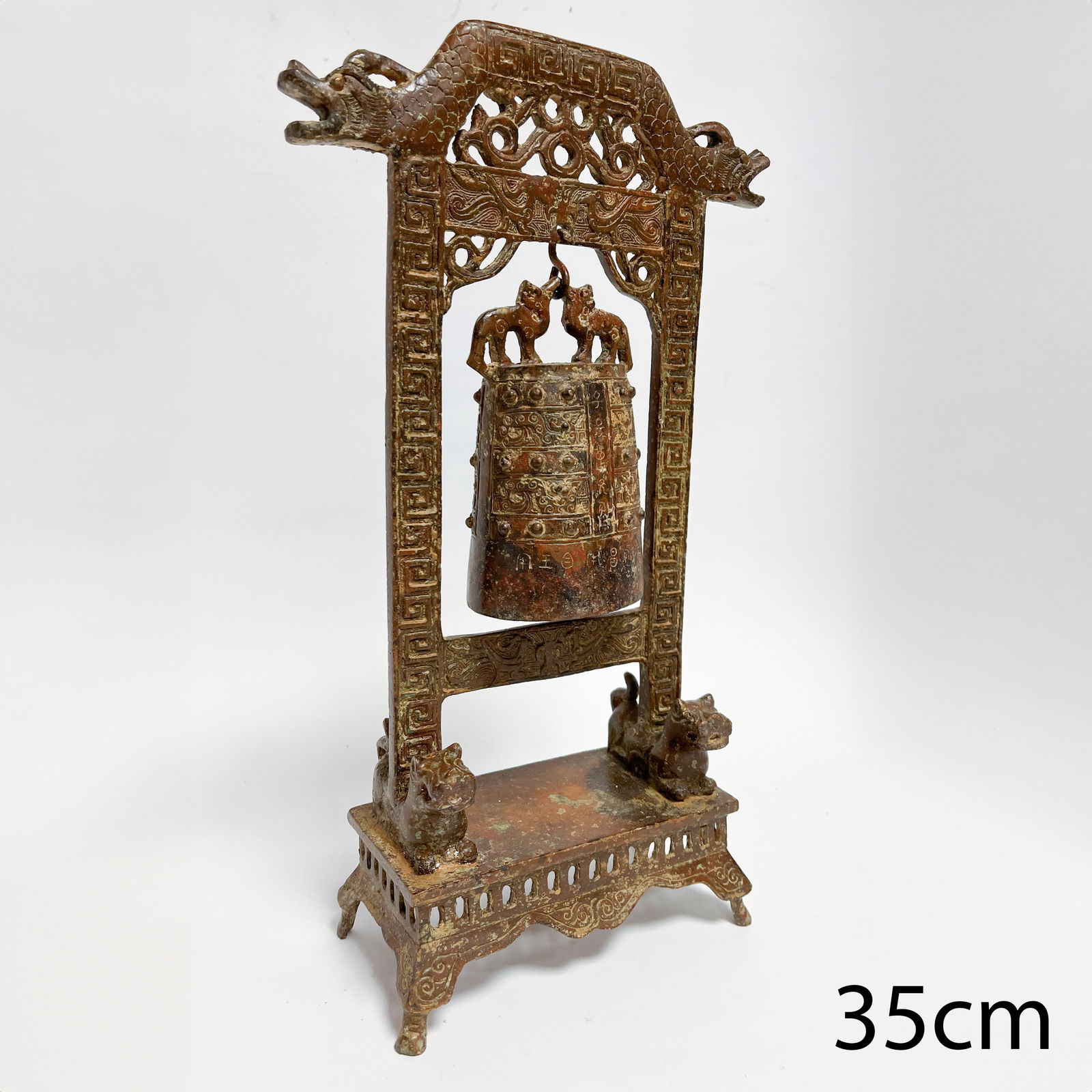 A CHINESE ARCHAIC FORM BRONZE BELL WITH STAND: A CHINESE ARCHAIC FORM BRONZE BELL WITH STAND,H. 35 cm.