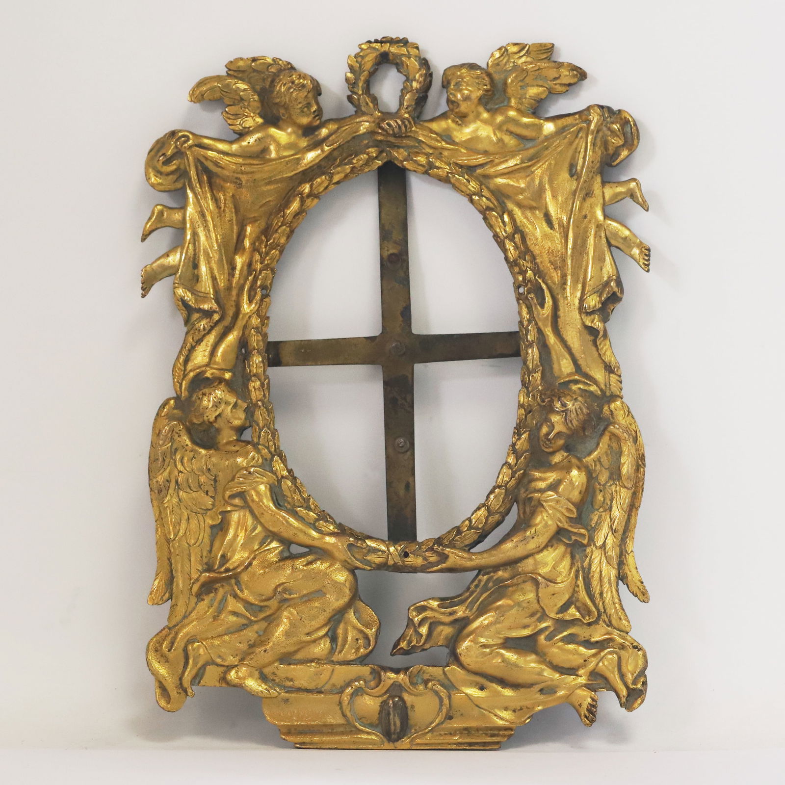 FINE AND LARGE ANTIQUE GILT METAL FRAME: FINE AND LARGE ANTIQUE GILT METAL FRAME.970 grams.designed as 2 angels holding the laurel border.With 2 putti holding the curtain to the side, giving a full view of the frame.L. 23,5 cm. W. 16 cm.