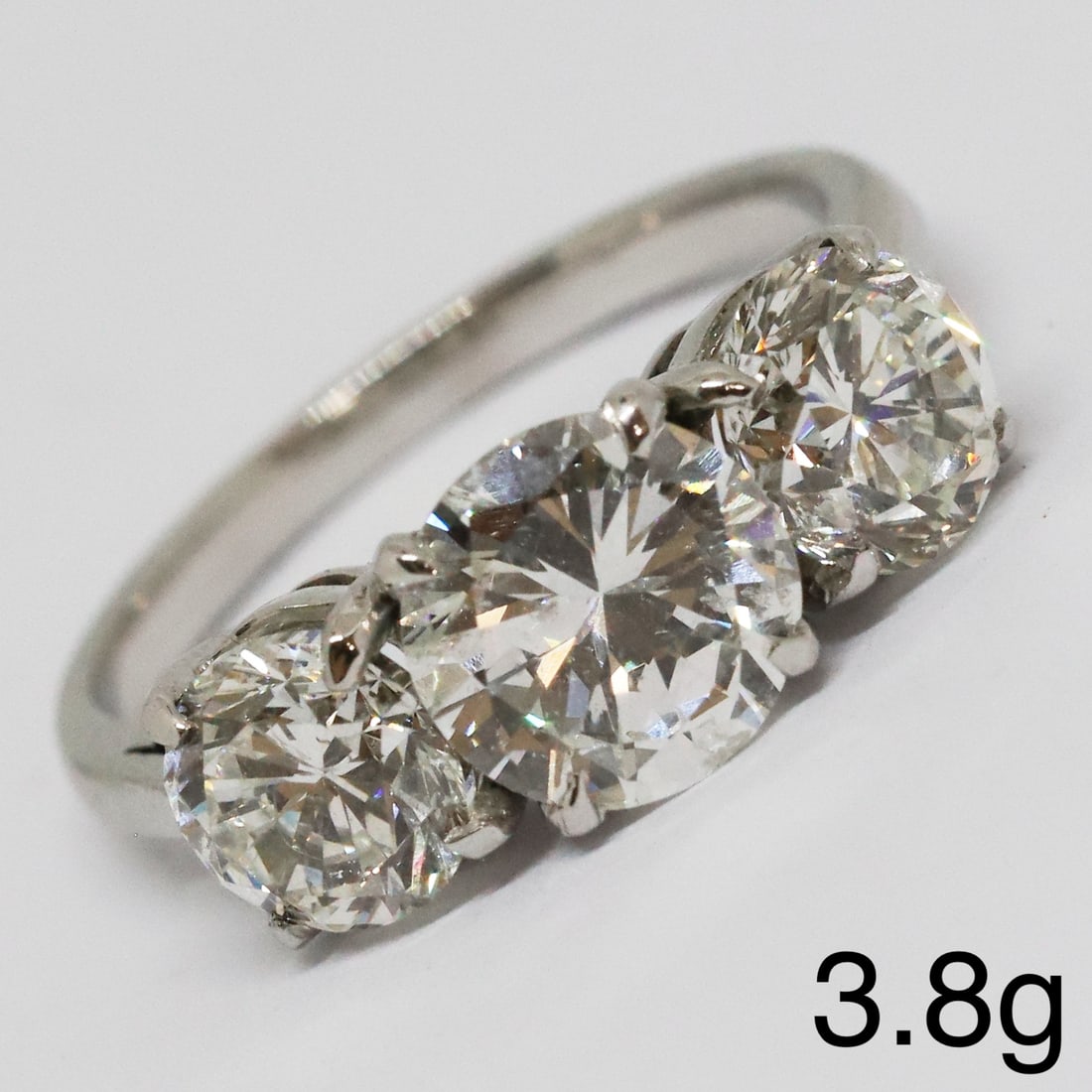 FINE 3-STONE DIAMOND RING: FINE 3-STONE DIAMOND RING,3,8 grams, testing high carat gold.Fine centre diamond of approx. 1.40 ct.Side diamonds of approx. 1 ct. each.Totalling approx. 3.40 ct.Size L 1/2.