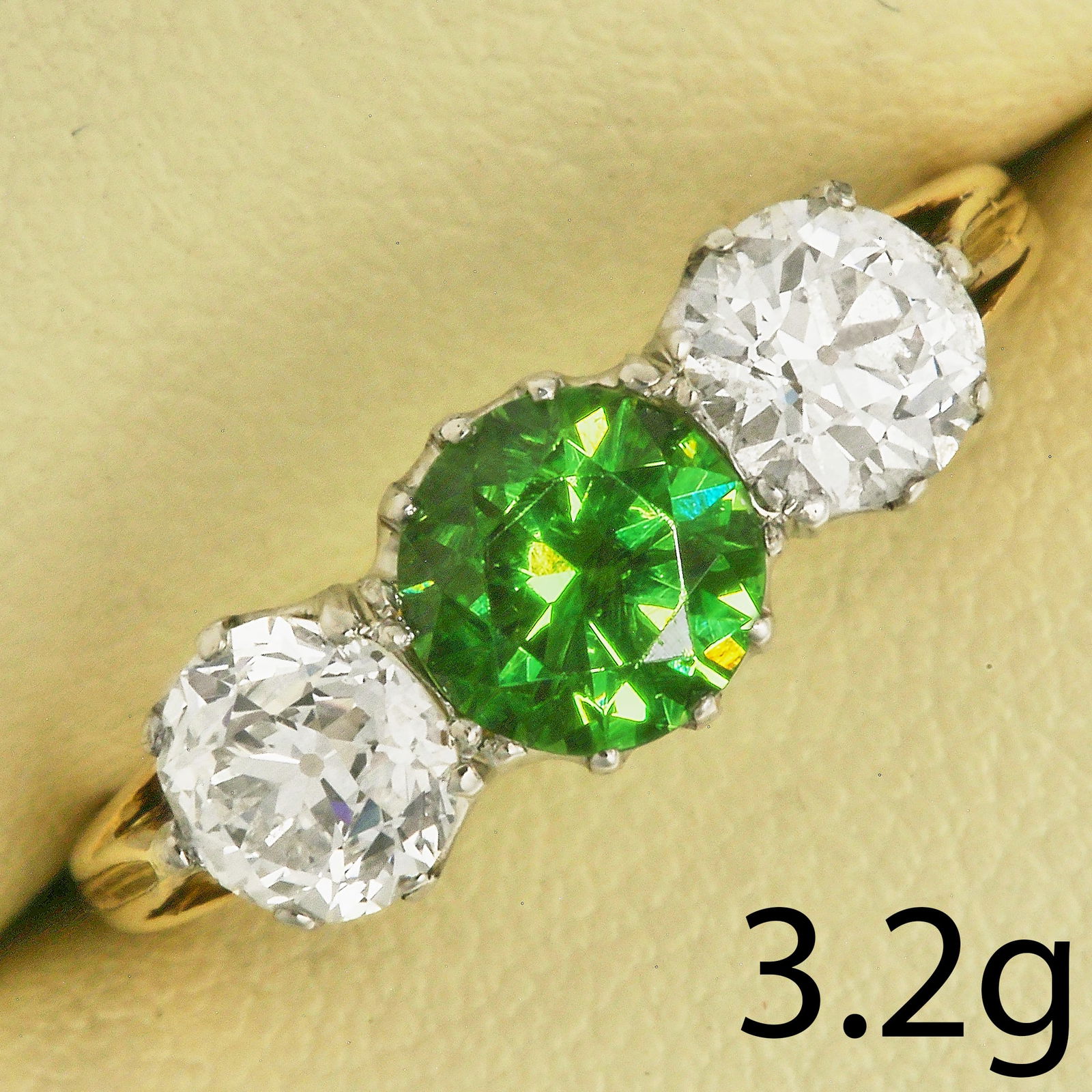 FINE DEMANTOID GARNET AND DIAMOND 3-STONE RING: FINE DEMANTOID GARNET AND DIAMOND 3-STONE RING,3,2 grams, testing high carat gold and platinum.Rare rIch and vibrant demantoid garnet of approx. 1 ct.Diamonds bright and lively, totalling approx. 1.40