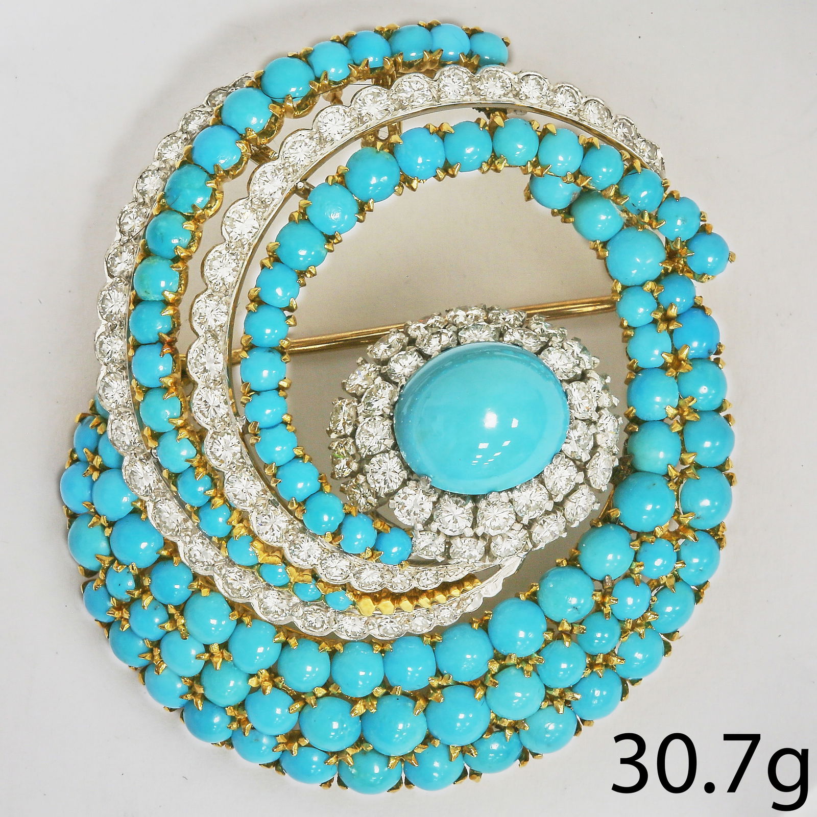 FINE TURQUOISE AND DIAMOND SWIRL BROOCH/PENDANT: FINE TURQUOISE AND DIAMOND SWIRL BROOCH/PENDANT,30.7 grams, testing high carat gold.Large turquoise to the centre, from where in swirl design further set with turquoise and diamonds.Diamonds bright an