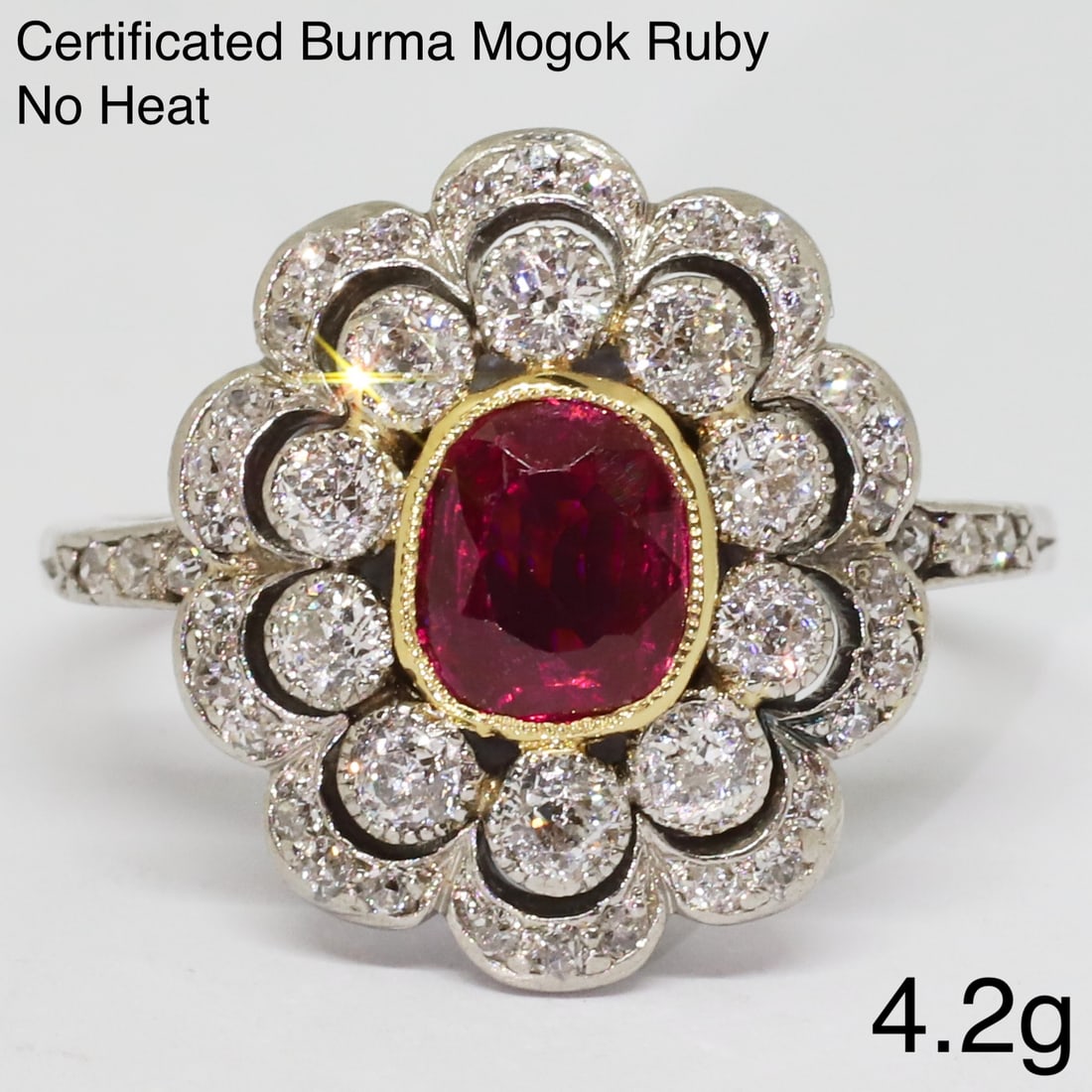 CERTIFICATED BURMA RUBY AND DIAMOND CLUSTER RING: CERTIFICATED BURMA RUBY AND DIAMOND CLUSTER RING,4,2 grams, testing platinum.Rich and vibrant ruby of approx. 0.95 ct. (Certificated, Burma, 'Mogok', No heat.Diamonds bright and lively.Size N.See cert