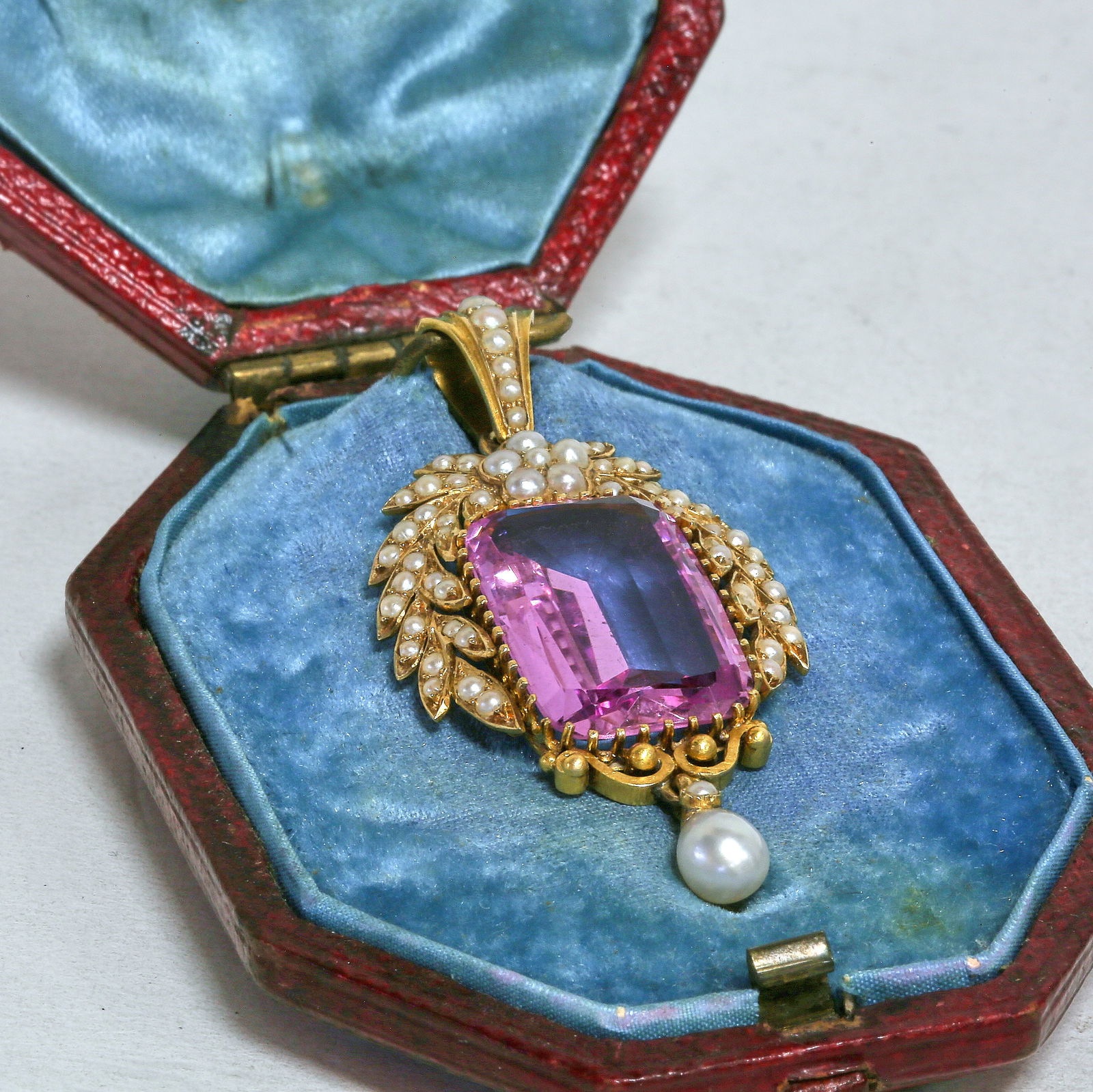 MAGNIFICENT CERTIFICATED PINK TOPAZ AND PEARL PENDANT: MAGNIFICENT CERTIFICATED PINK TOPAZ AND PEARL PENDANT,10.2 grams, testing high carat gold.A magnificent antique pendant set with a certificated natural pink topaz of exceptional colour and clarity,